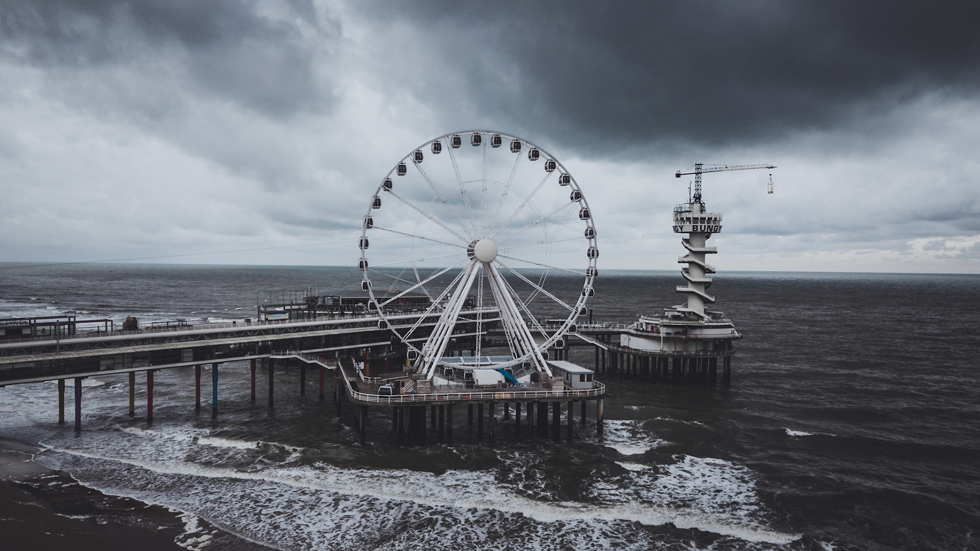 Scheveningen pier with the big wheel and the freefall tower on a rainy summer day
