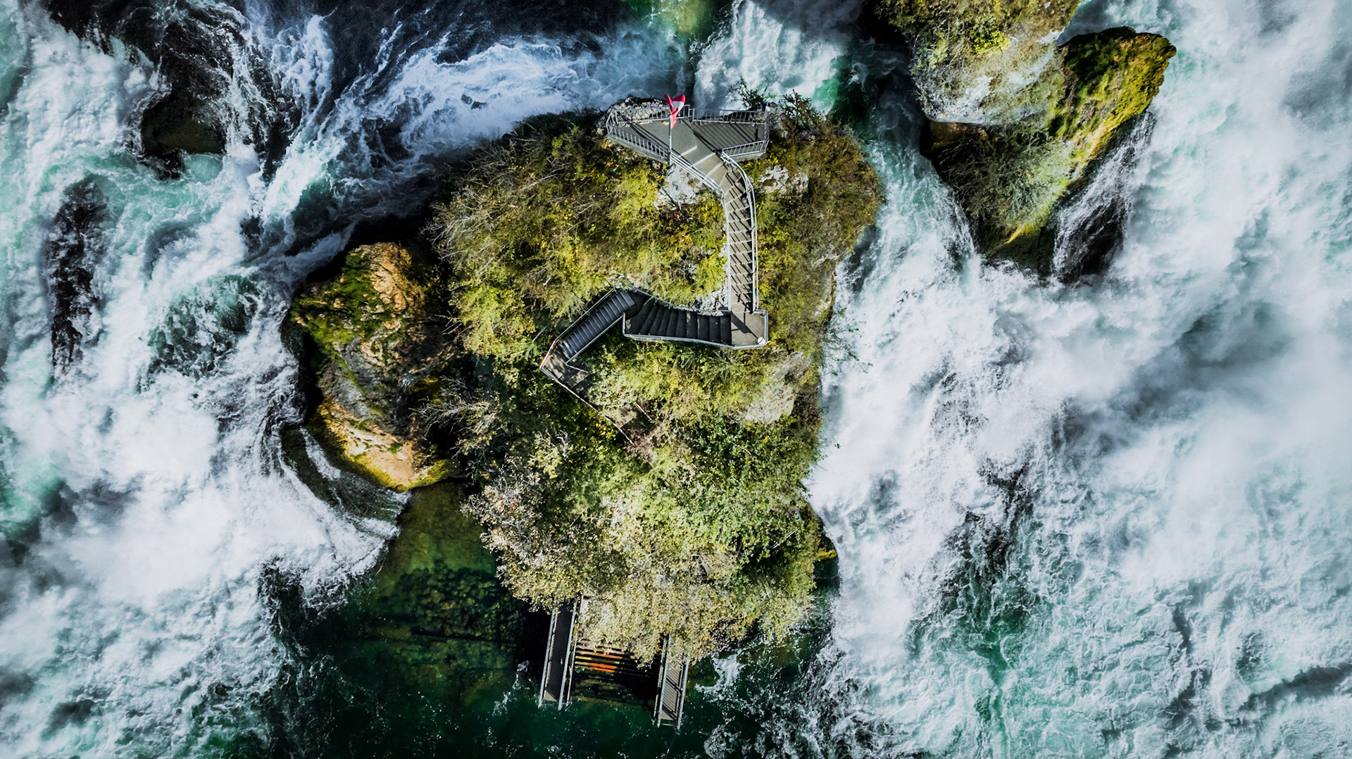 The Rhine Falls is a waterfall located in Switzerland and the most powerful waterfall in Europe. The falls are located on the High Rhine on the border between the cantons of Schaffhausen (SH) and Zürich (ZH). They are 150 metres wide and 23 metres high. In the winter months, the average water flow is 250 m3/s, while in the summer, the average water flow is 600 m3/s.