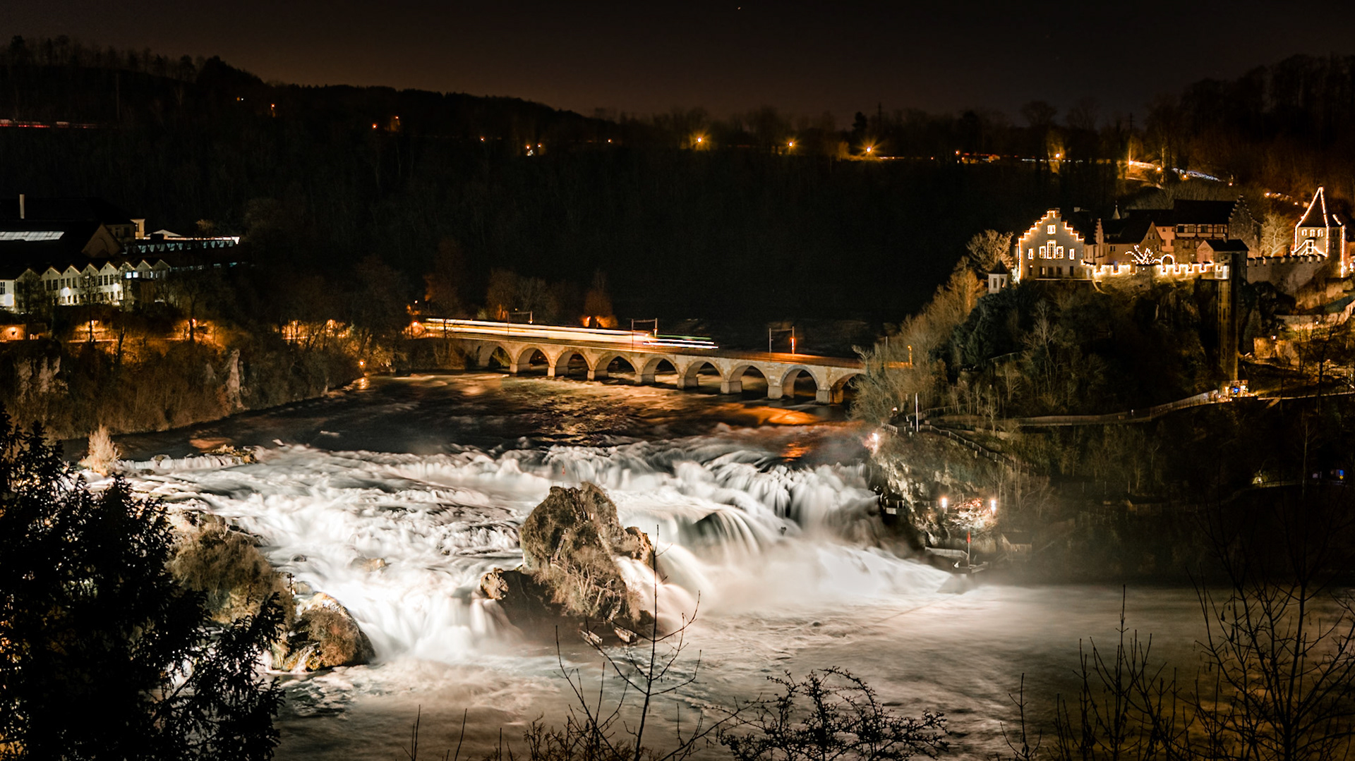 Panorama des Rheinfalls mit Schloss Lauffen und dem SIG-Areal bei Nacht