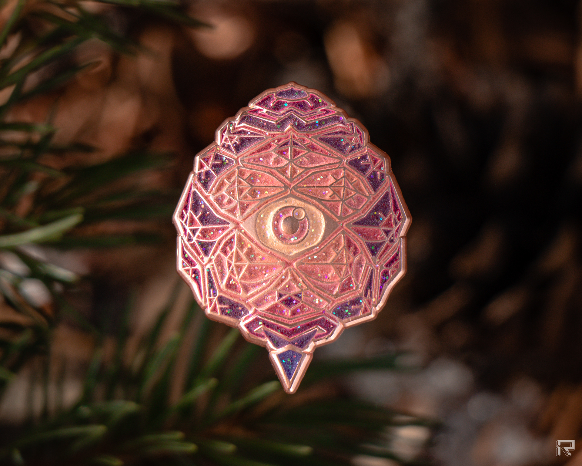 Enamel pin of a small pinecone with an eye