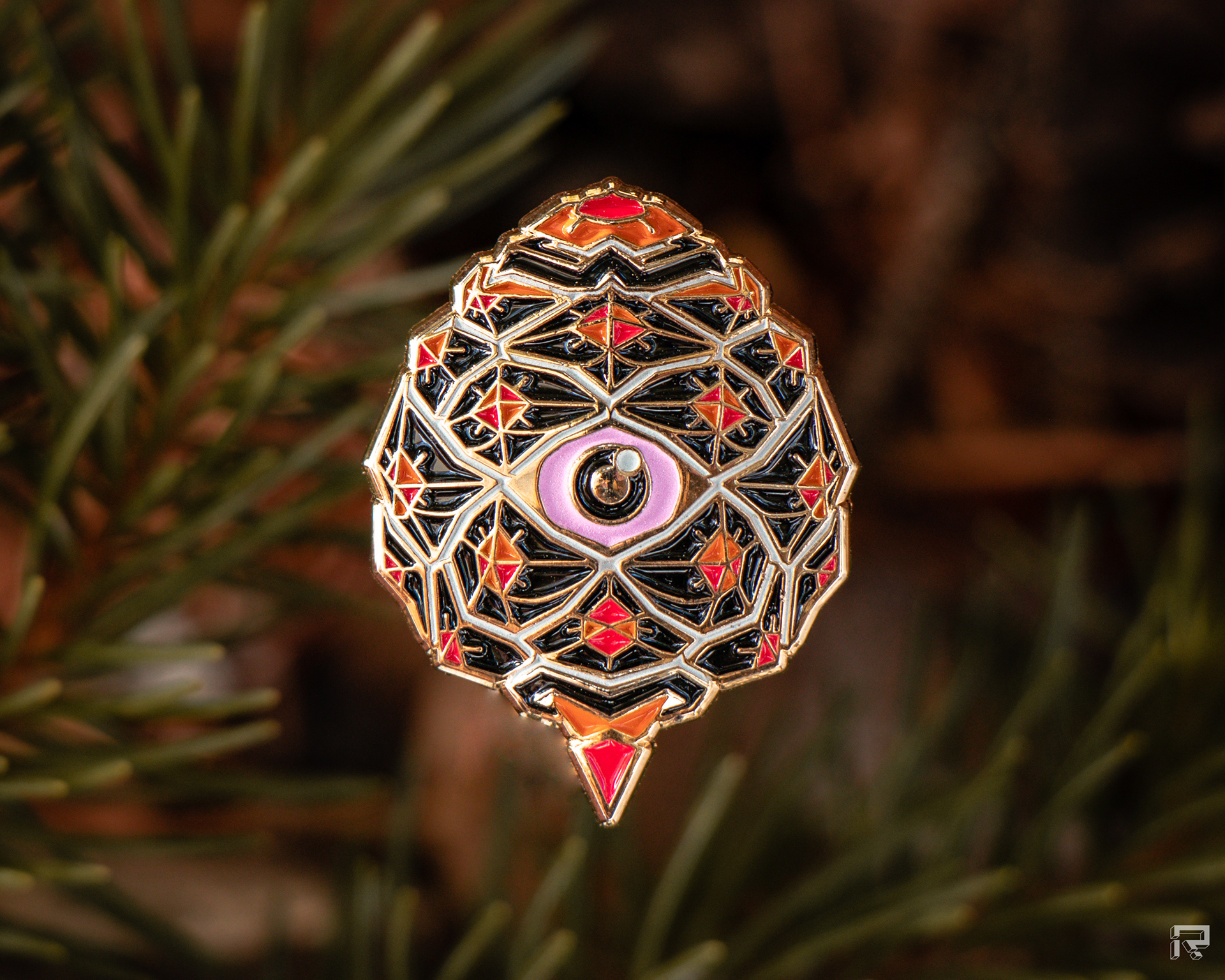 Enamel pin of a small pinecone with an eye