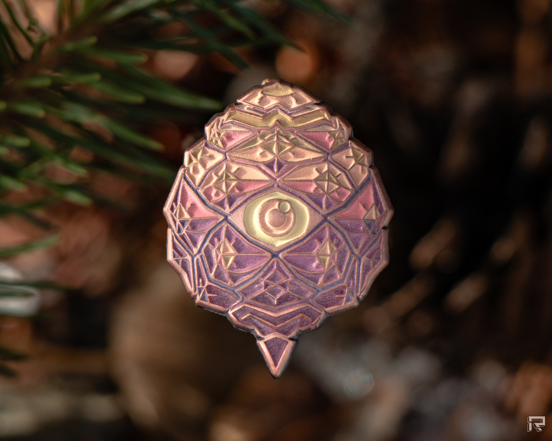 Enamel pin of a small pinecone with an eye
