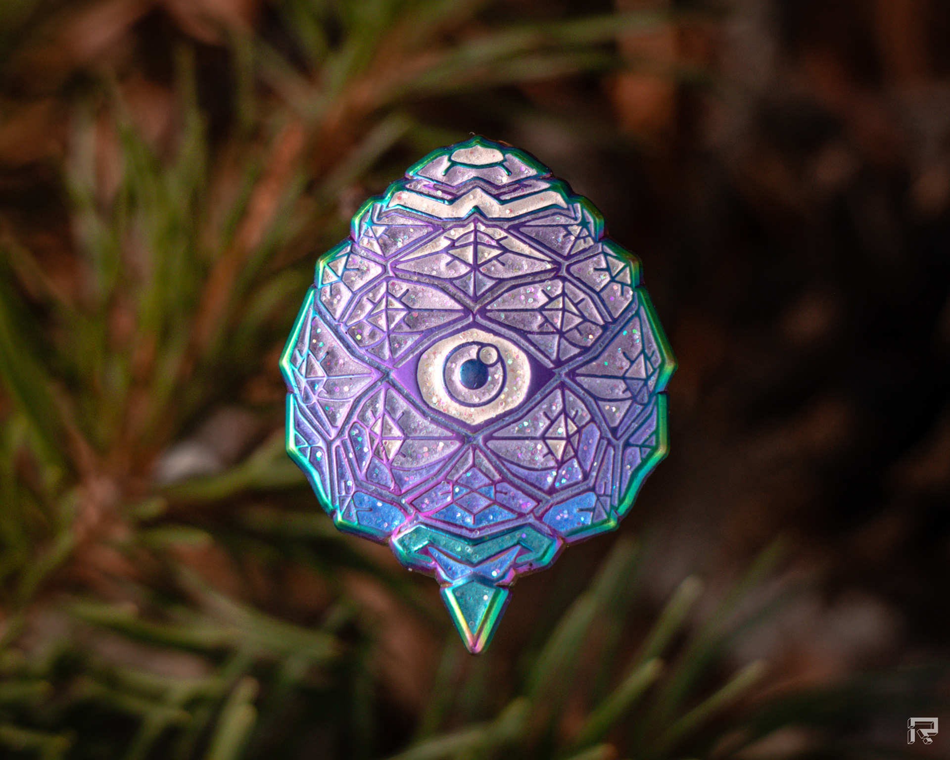 Enamel pin of a small pinecone with an eye