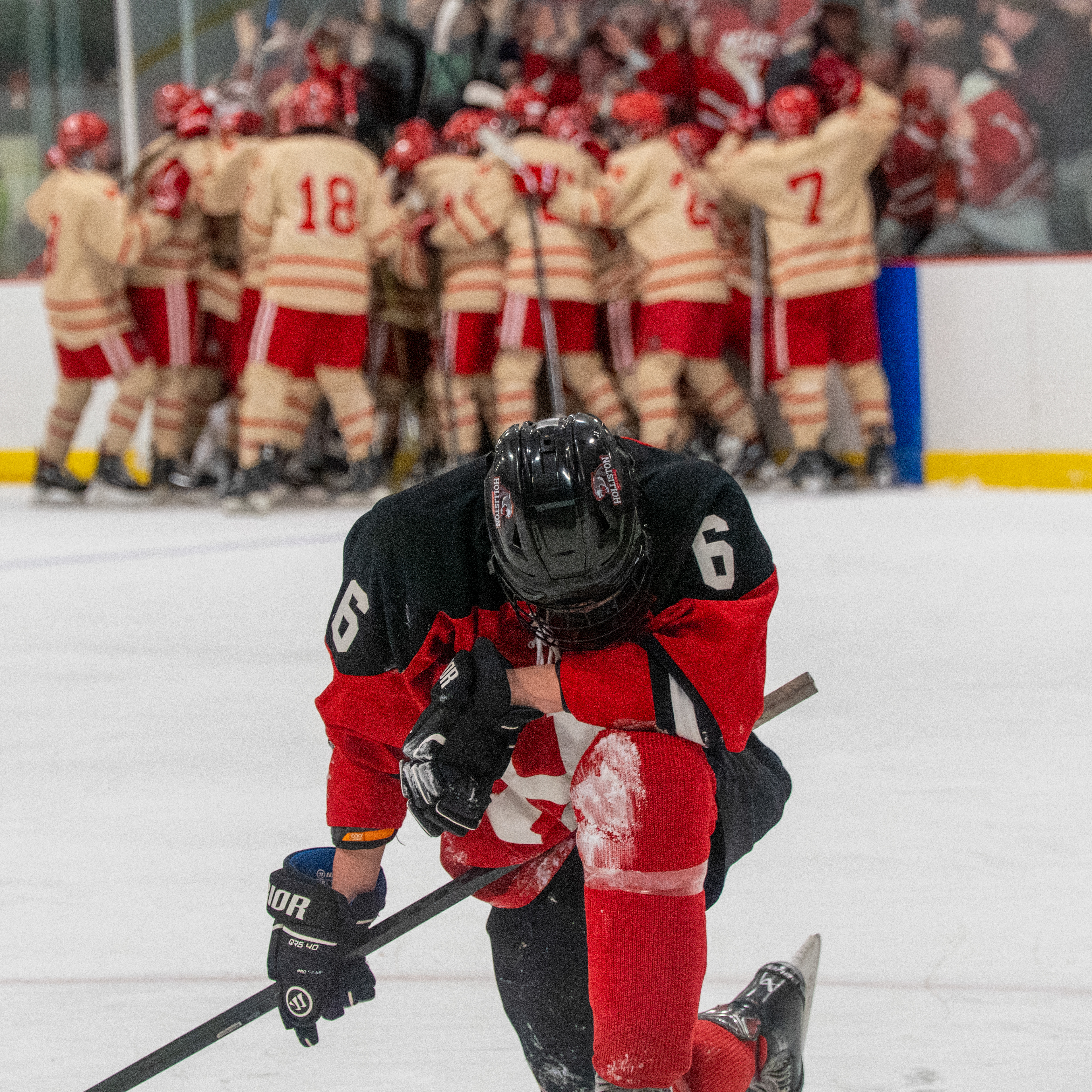 Holliston High School junior Oliver Lareau takes a moment while the Melrose boys' hockey team celebrates its 3-2 overtime win in the first round of the MIAA Division 3 state tournament on Feb. 26, 2025 at Kasabuski Arena in Saugus, Mass.