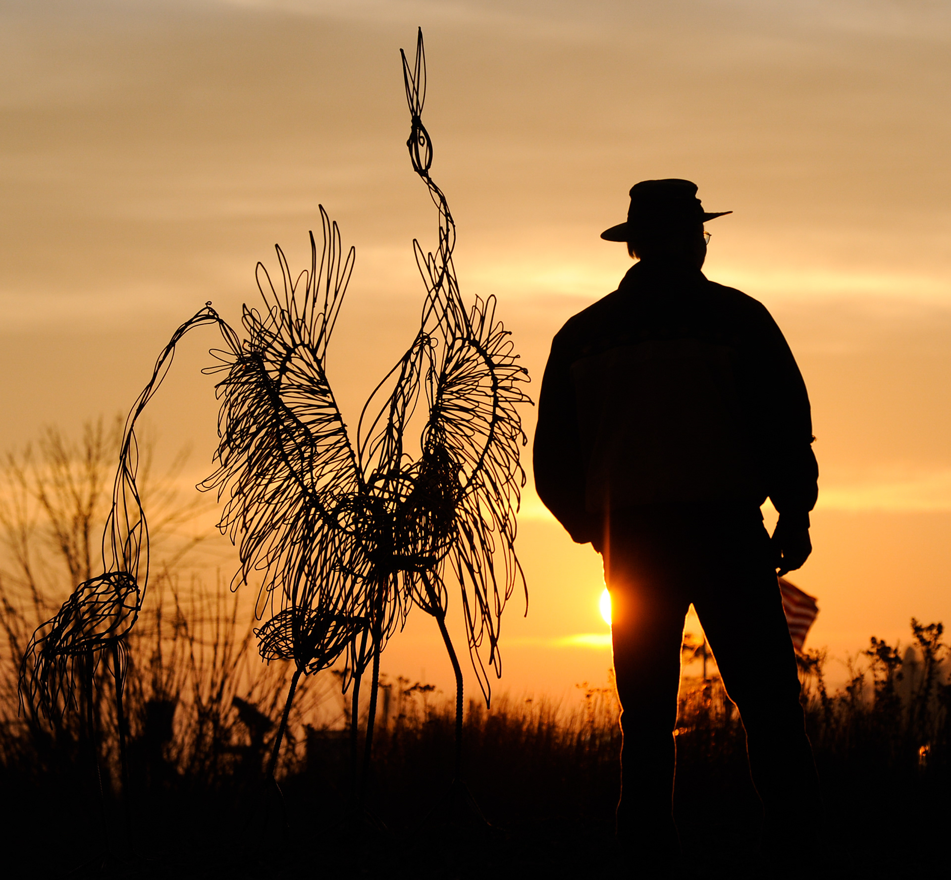 Sculptor Jim Dehne of Newton stands with his sculpture "Dancing Sand Hill Cranes" along the Mariners Trail Wednesday. Dehne designed the sculpture to look different in all kinds of light. "It'll just shine," said Dehne. Doug Sundin/HTR November 10, 2010 Two Rivers