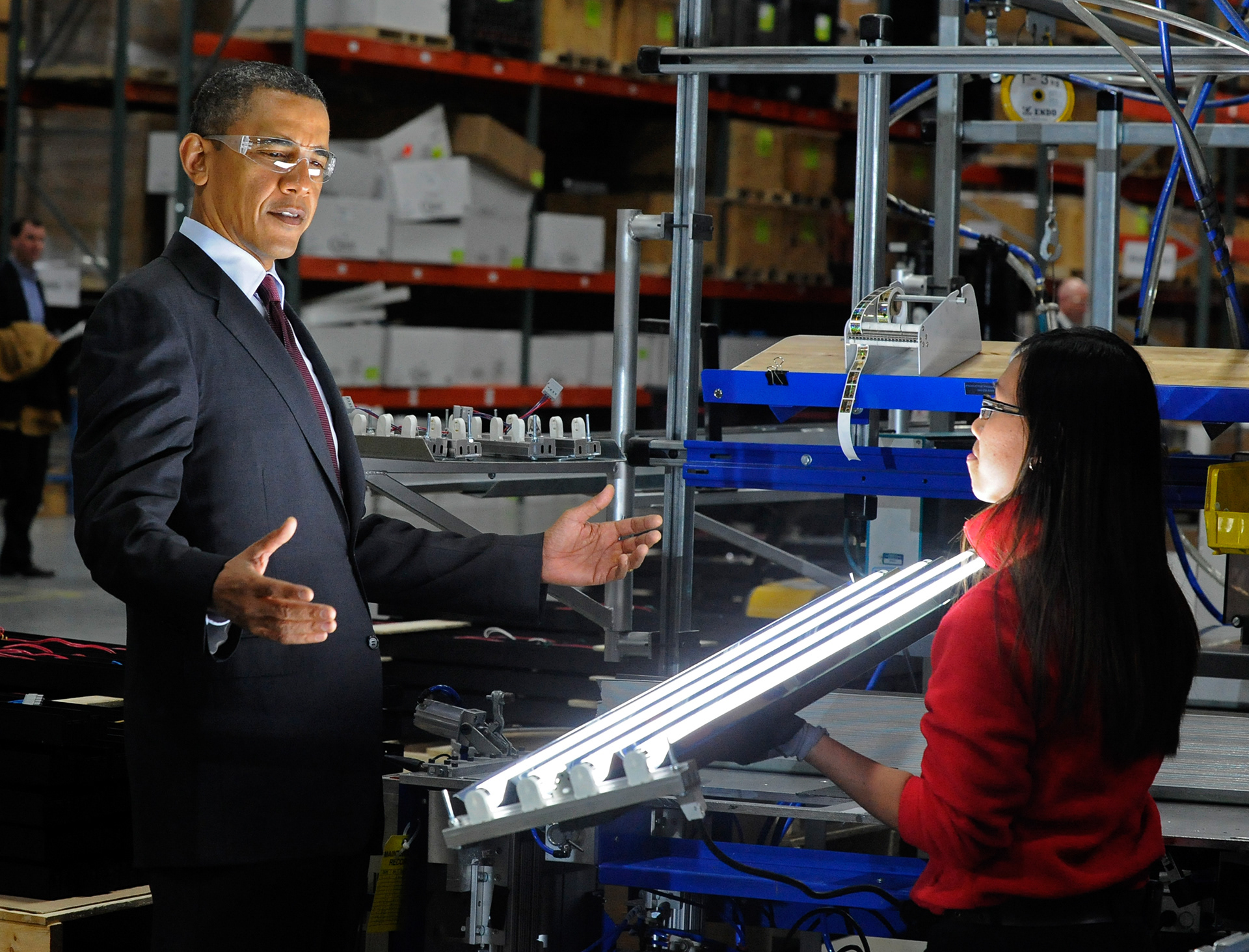 President Barack Obama beholds an Orion Energy Systems' high-intensity modular fluorescent light held by Marisol DeBaushe of Orion during Obama's visit to Manitowoc on Wednesday. Obama also visited Skana Aluminum Co. and Tower Tech Systems. Doug Sundin/HTR January 26, 2011 Manitowoc. Printed in the Herald Times Reporter on 01/27/2011.