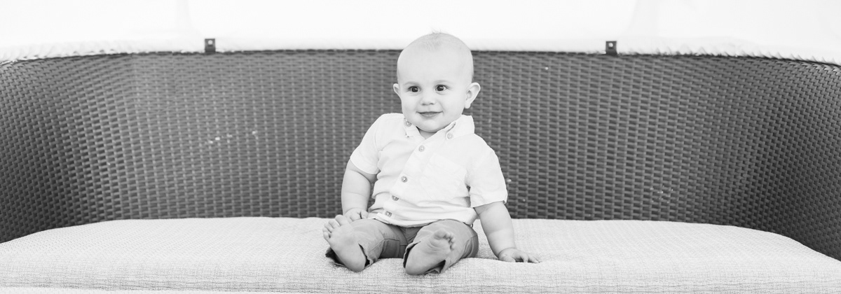 A black and white photo of a baby smiling, taken by MTP Photography
