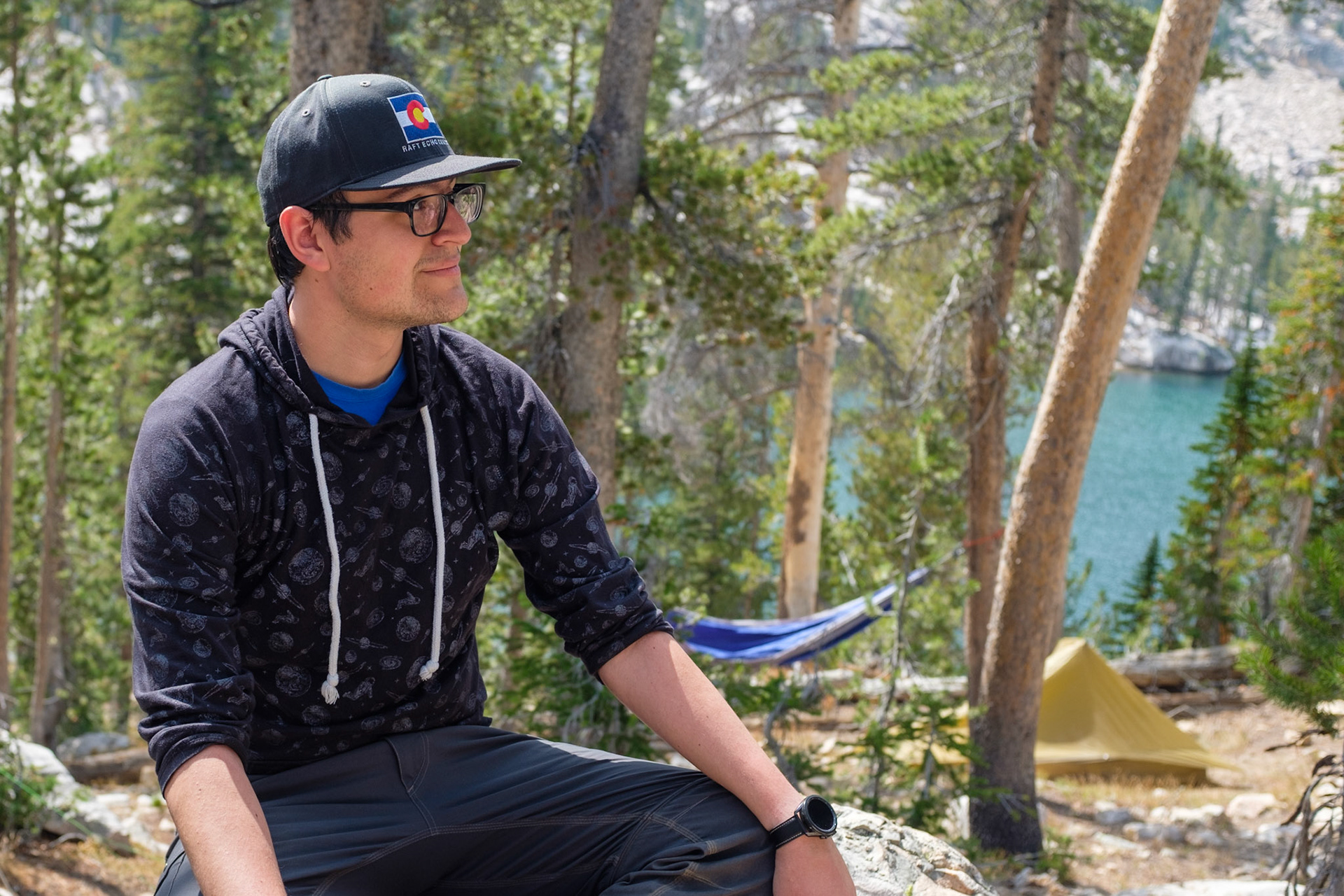 Matthew with hammock, tent and lake in the background.