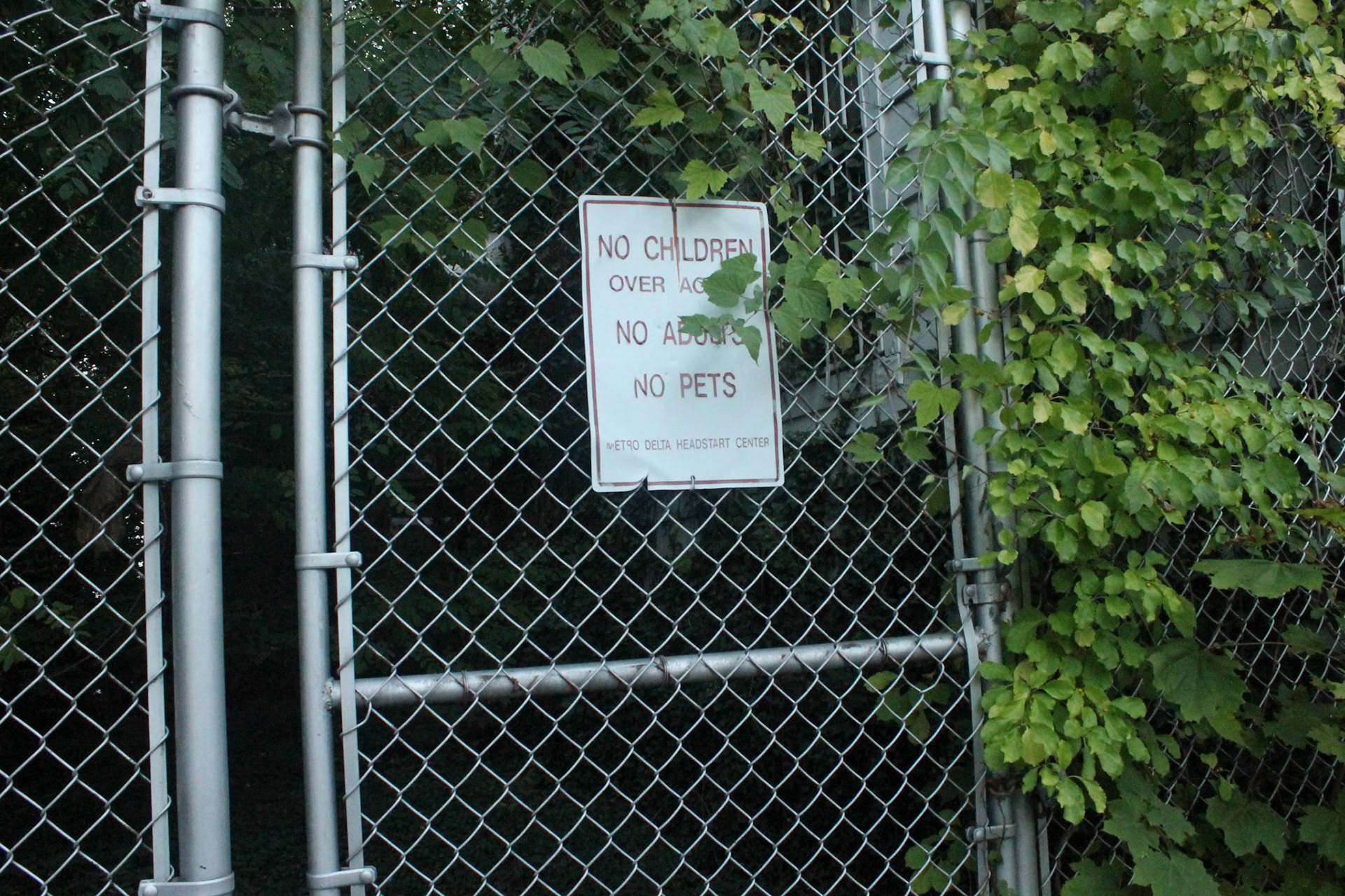 A deteriorated sign hangs on a fence to a children’s playground at an abandoned mansion in Reservoir Hill, Baltimore; Wednesday, September 22, 2022.