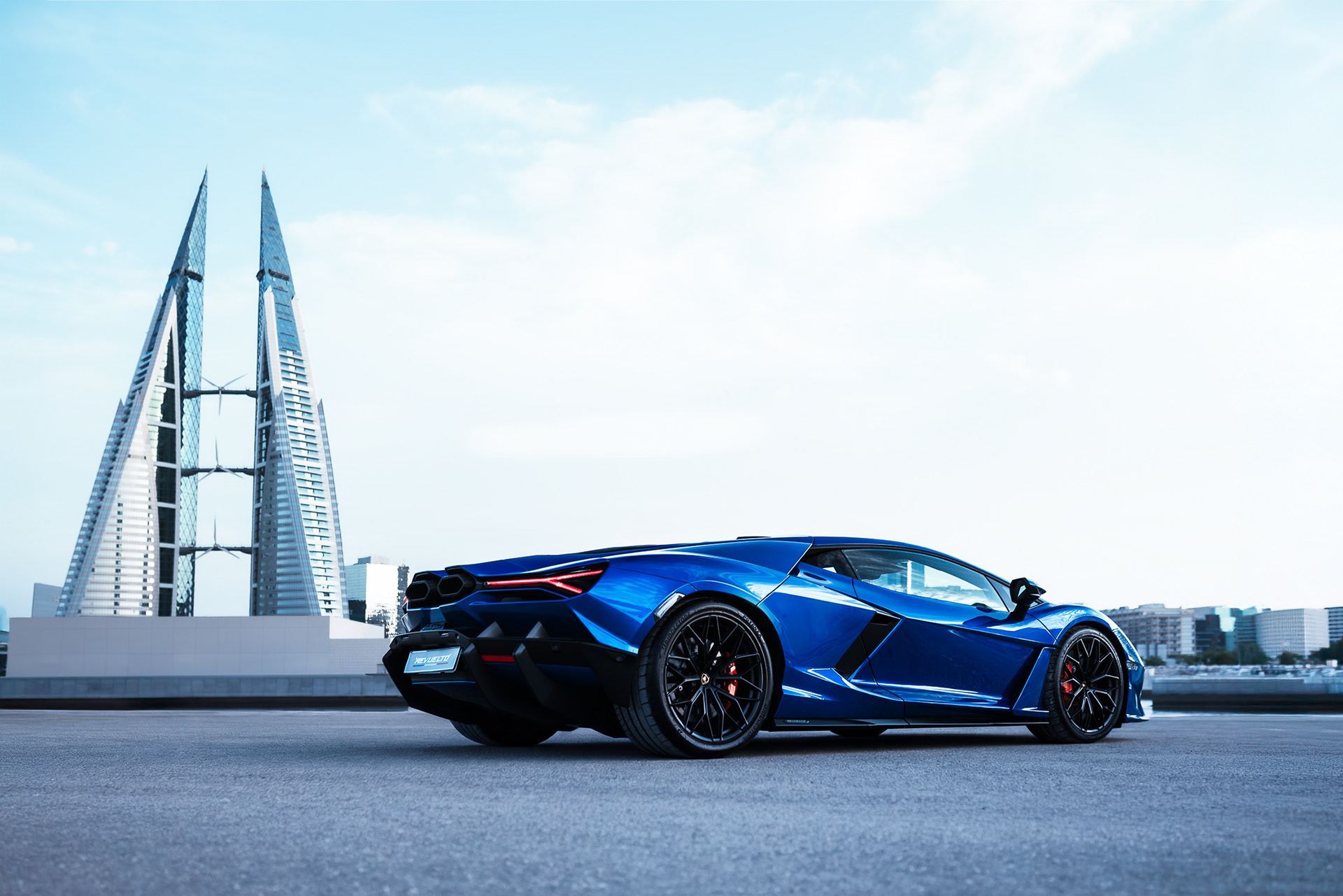 Lamborghini Revuelto side profile with the Bahrain World Trade Center towers in the background, Manama