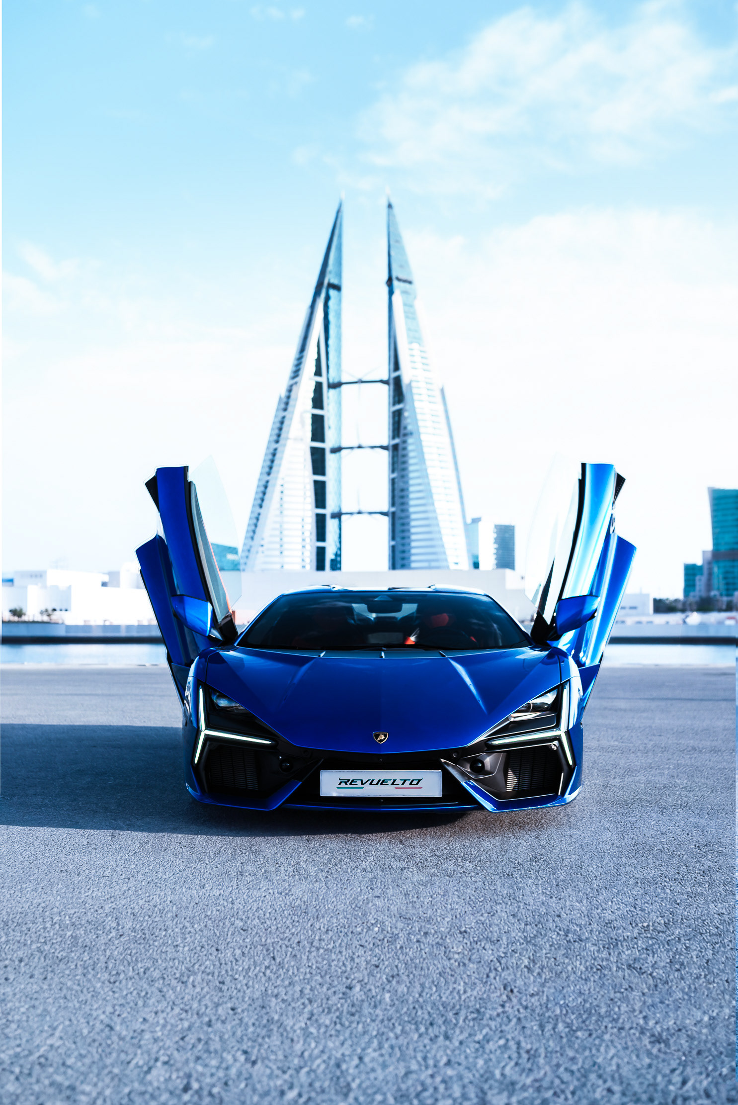Lamborghini Revuelto front view, scissor doors open, Bahrain World Trade Center behind, Manama