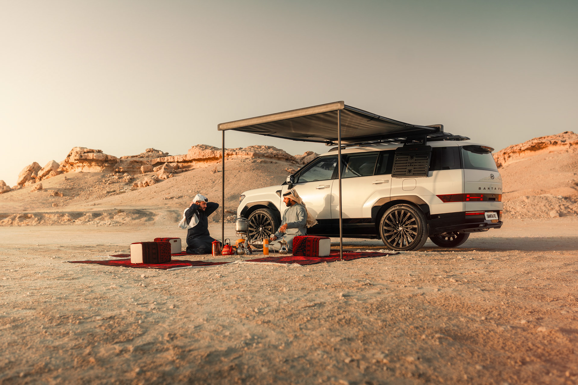 HYUNDAI SANTA FE parked under a shade awning with a desert rock formation backdrop, Bahrain — Shift Mootark