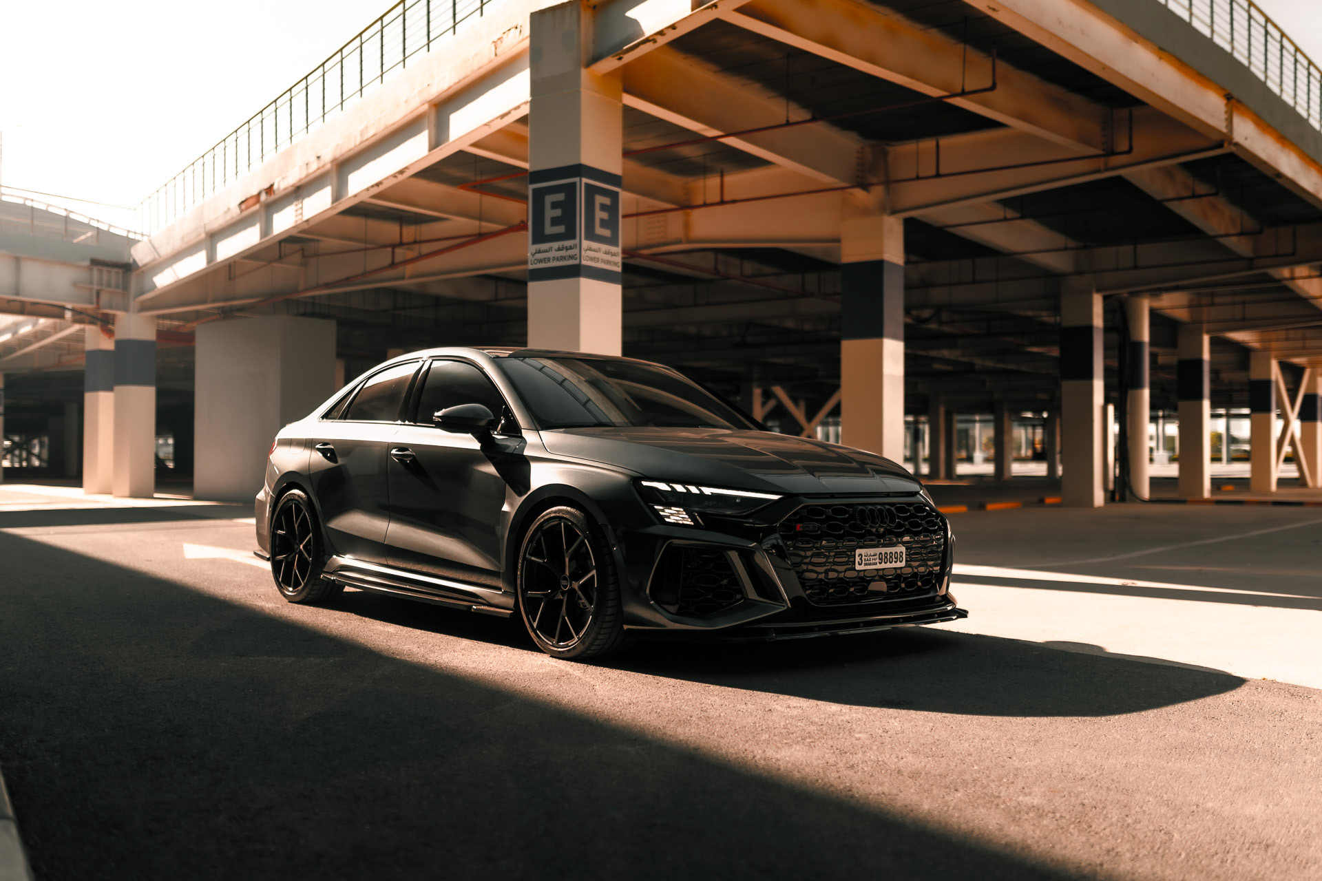 Audi RS3 2023 front view in Dubai parking structure with directional light and shadows