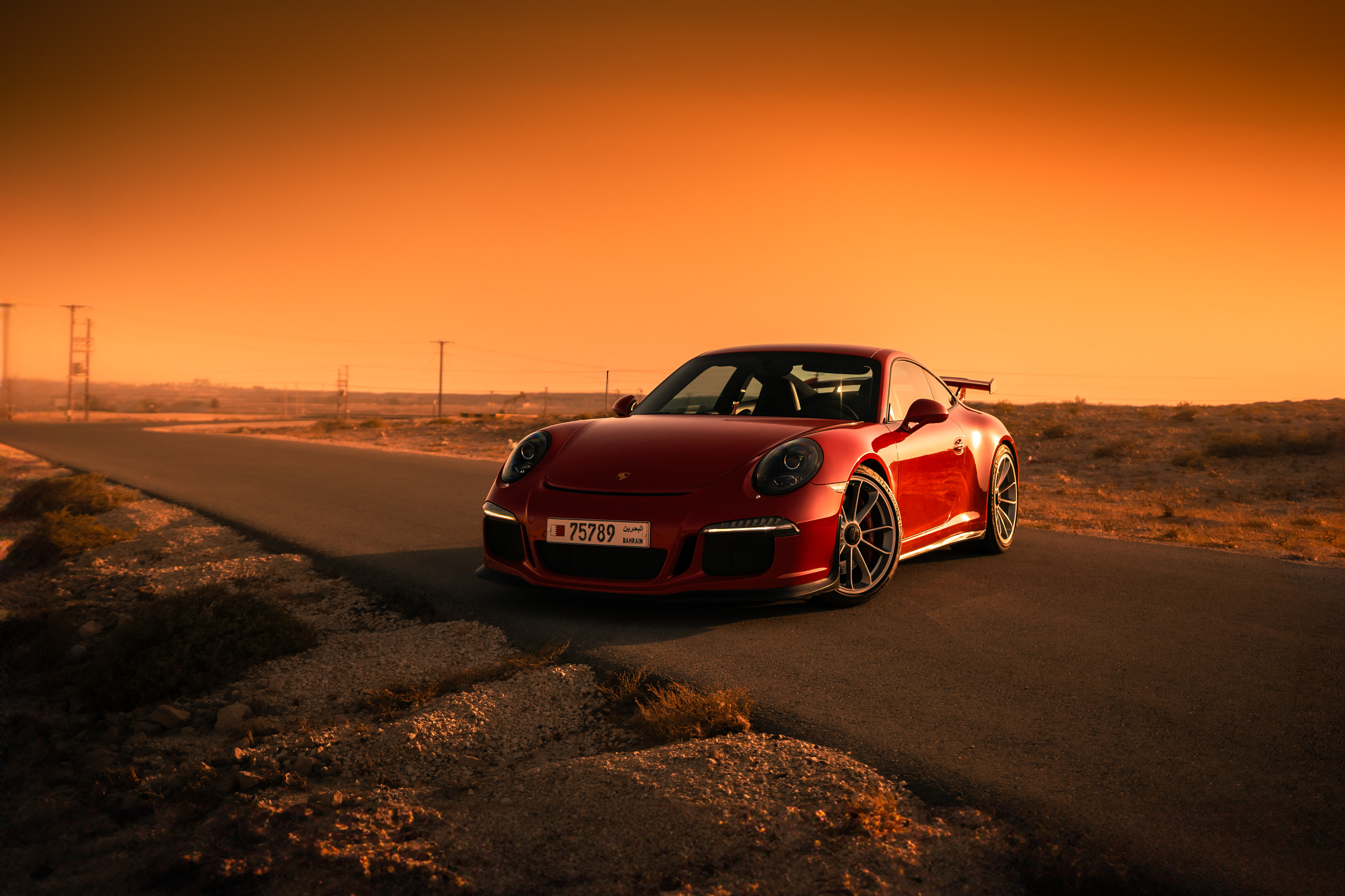 Porsche 911 GT3 front three‑quarter in golden desert light bahrain