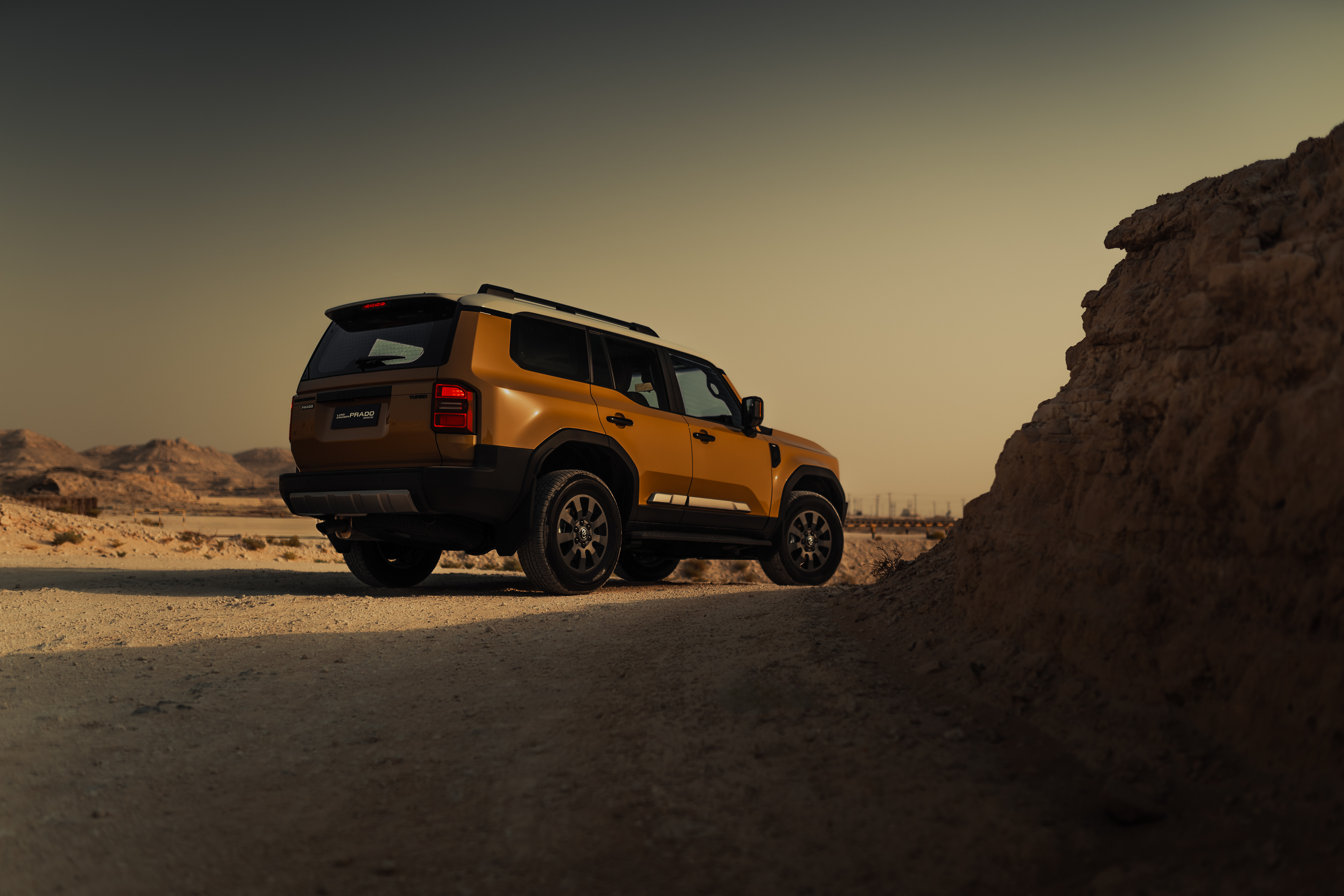 2024 Land Cruiser Prado, rear 3/4 low angle, desert trail, golden hour