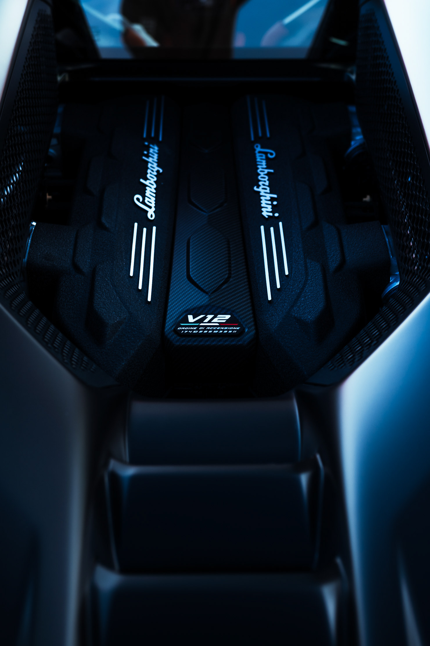 Lamborghini Revuelto V12 engine cover badge visible through the rear glass