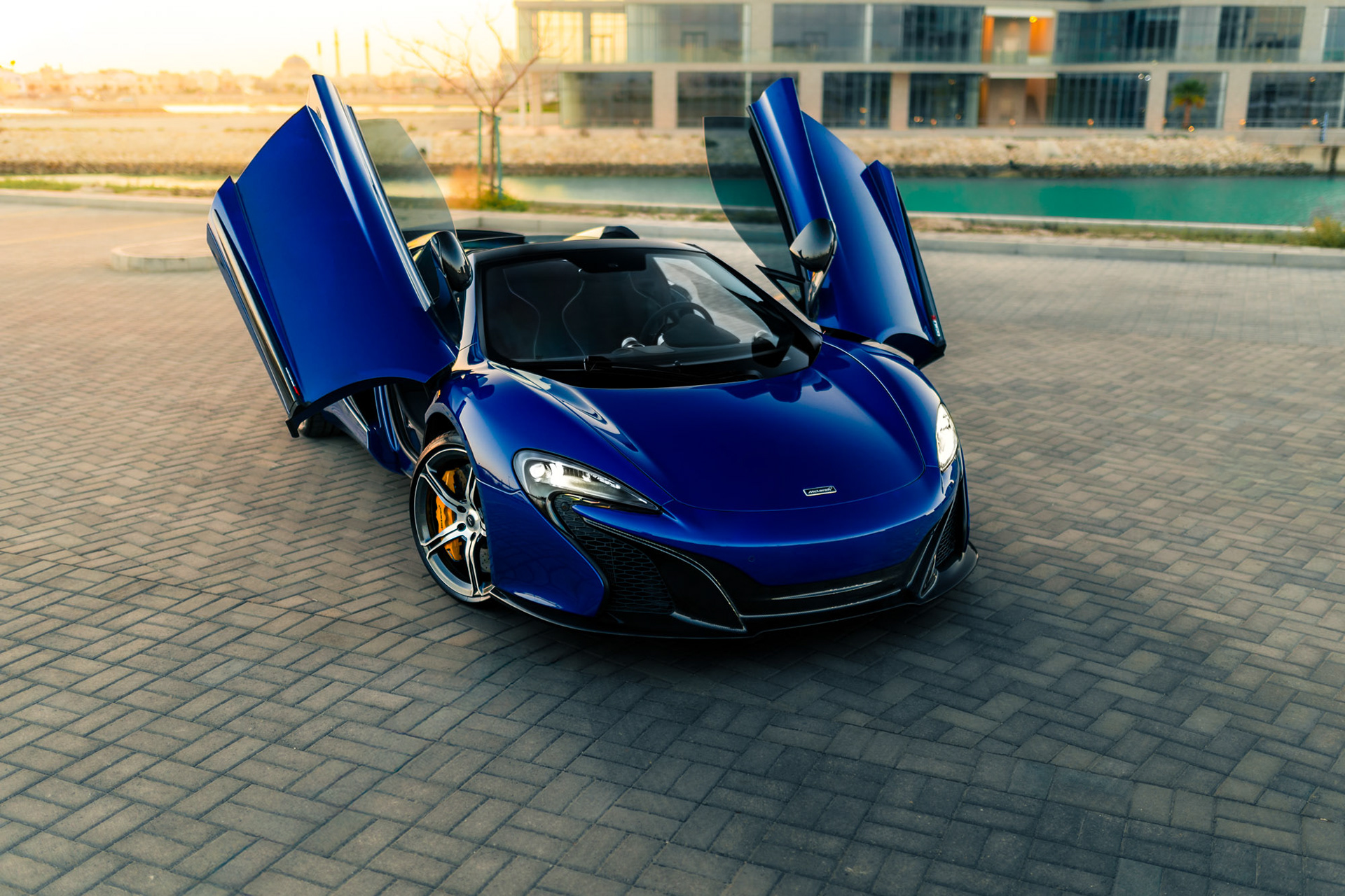 McLaren 650S Spider in Bahrain with dihedral doors open, captured at sunset to highlight the blue paint and carbon details.