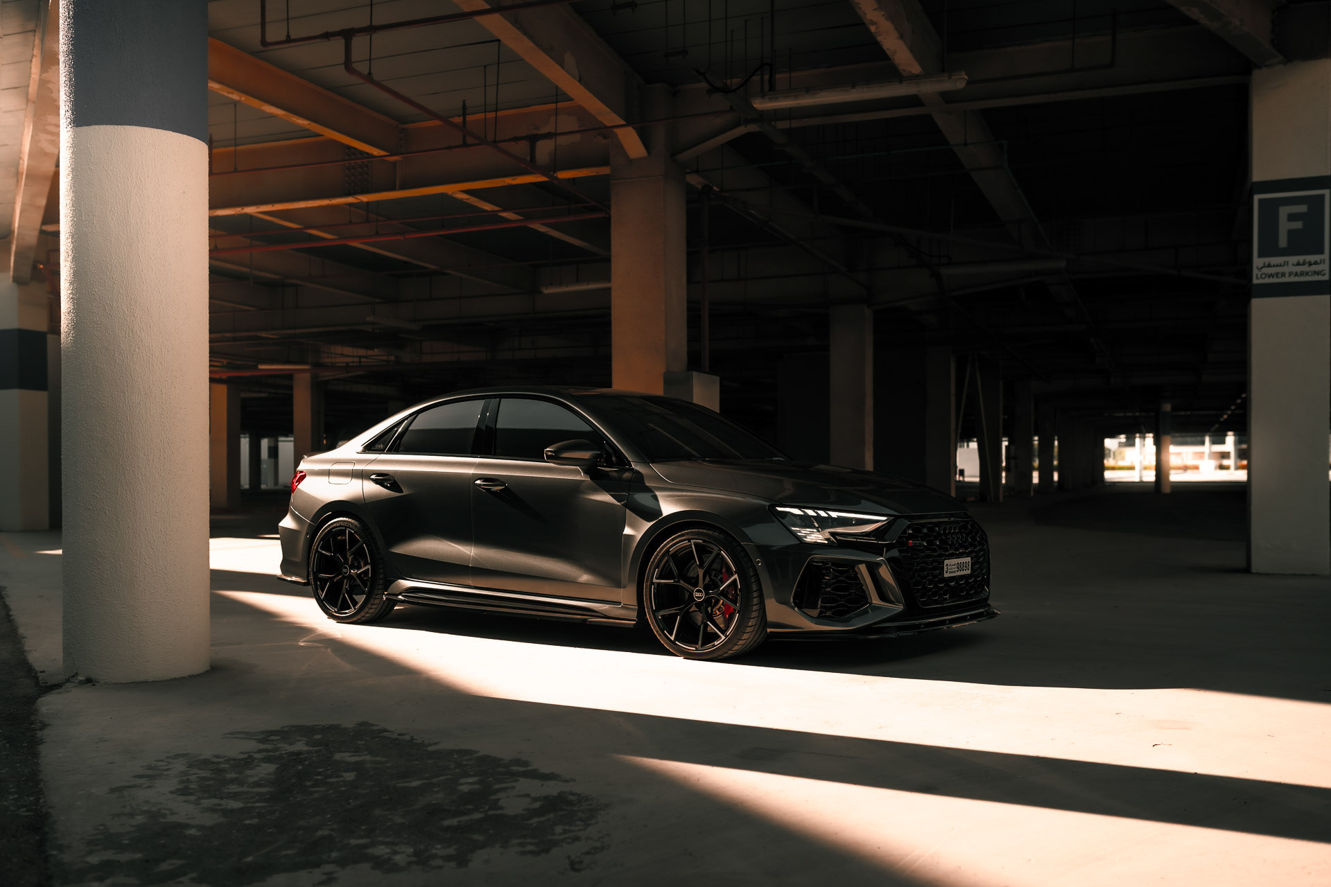 Audi RS3 2023 front view in Dubai parking structure with directional light and shadows
