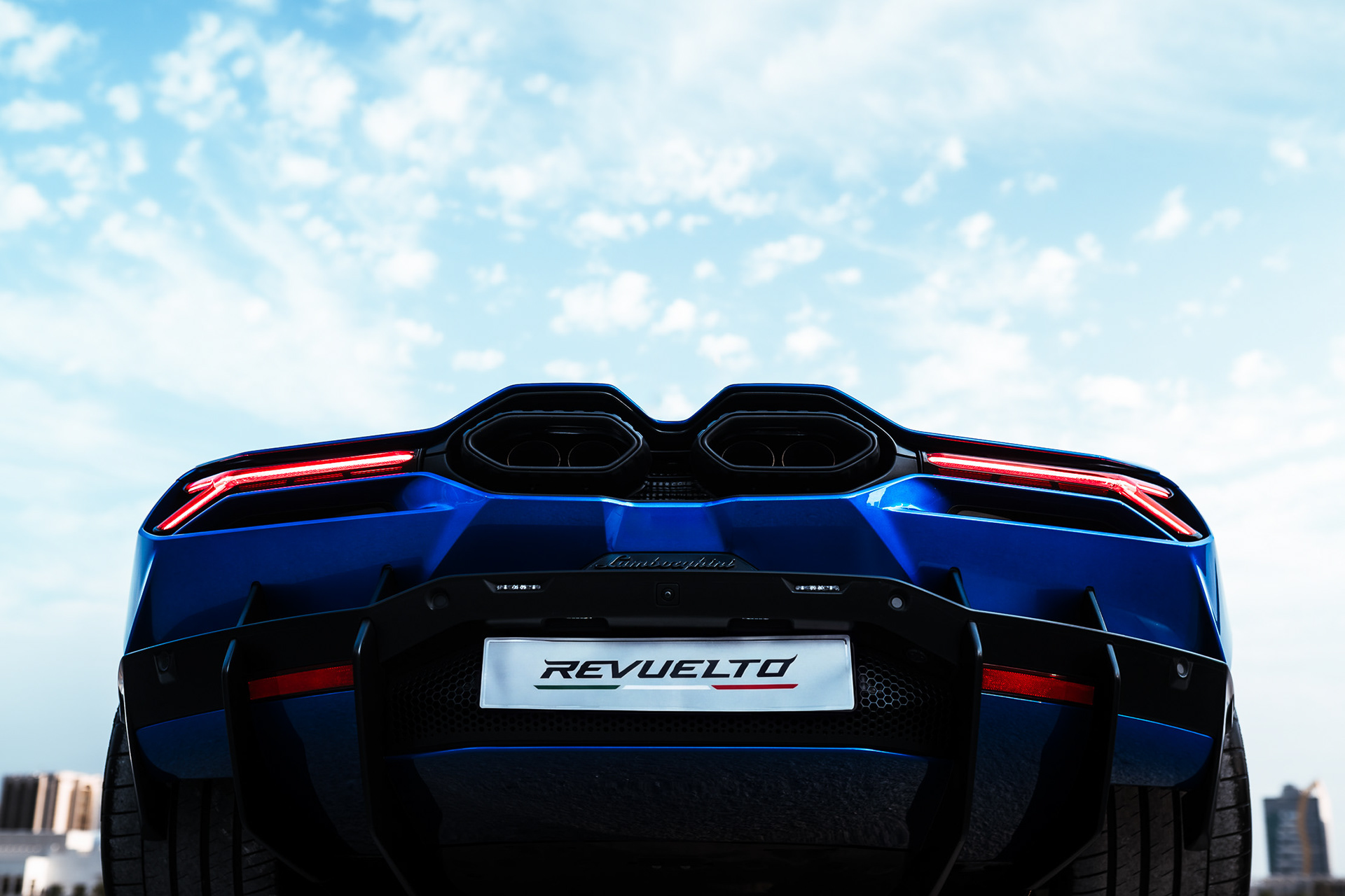 Straight rear view of the Lamborghini Revuelto showing hexagonal exhaust tips, diffuser, and REVUELTO badge
