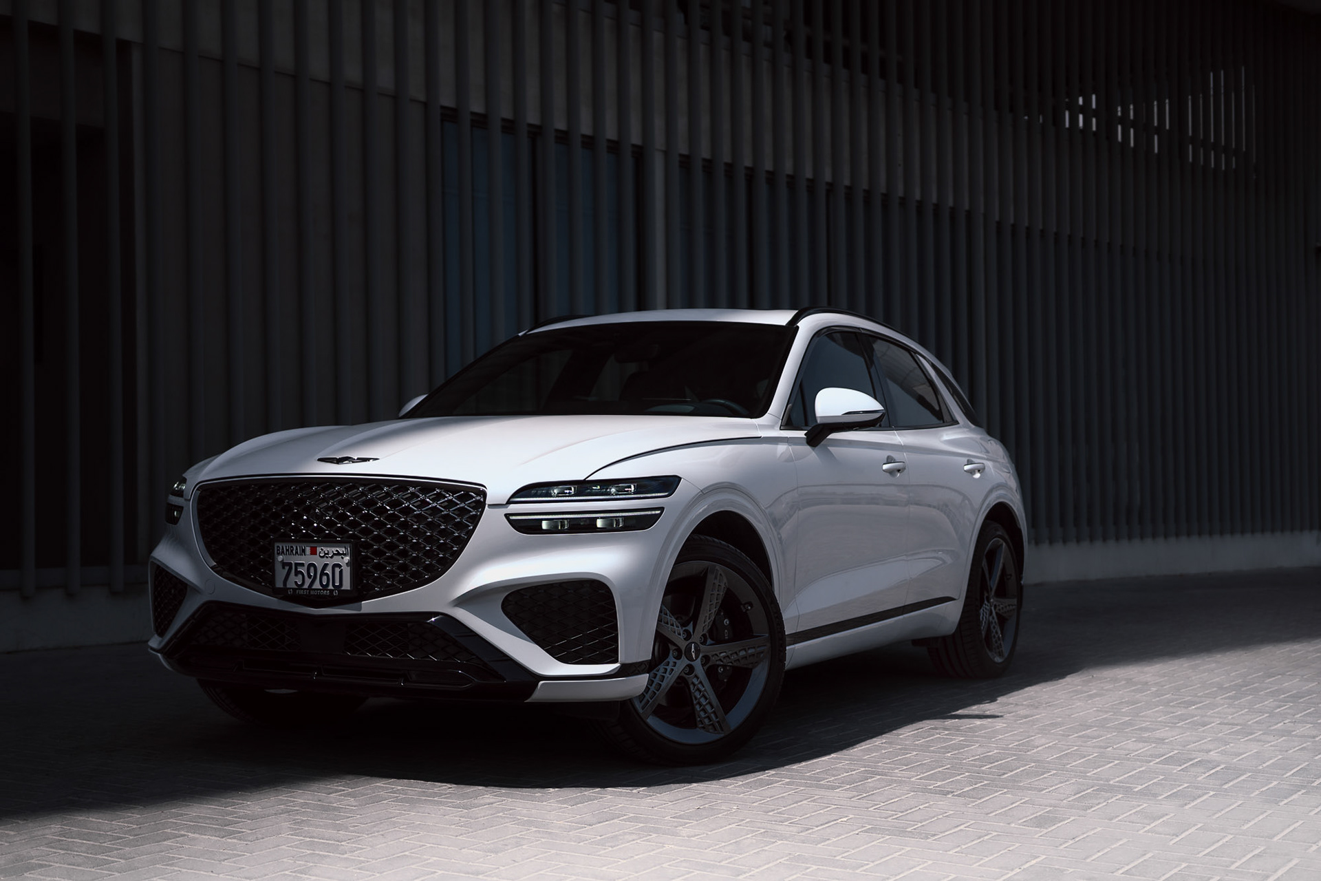 Genesis GV70 2022 front three-quarter view in Bahrain with minimal lighting and clean architecture backdrop