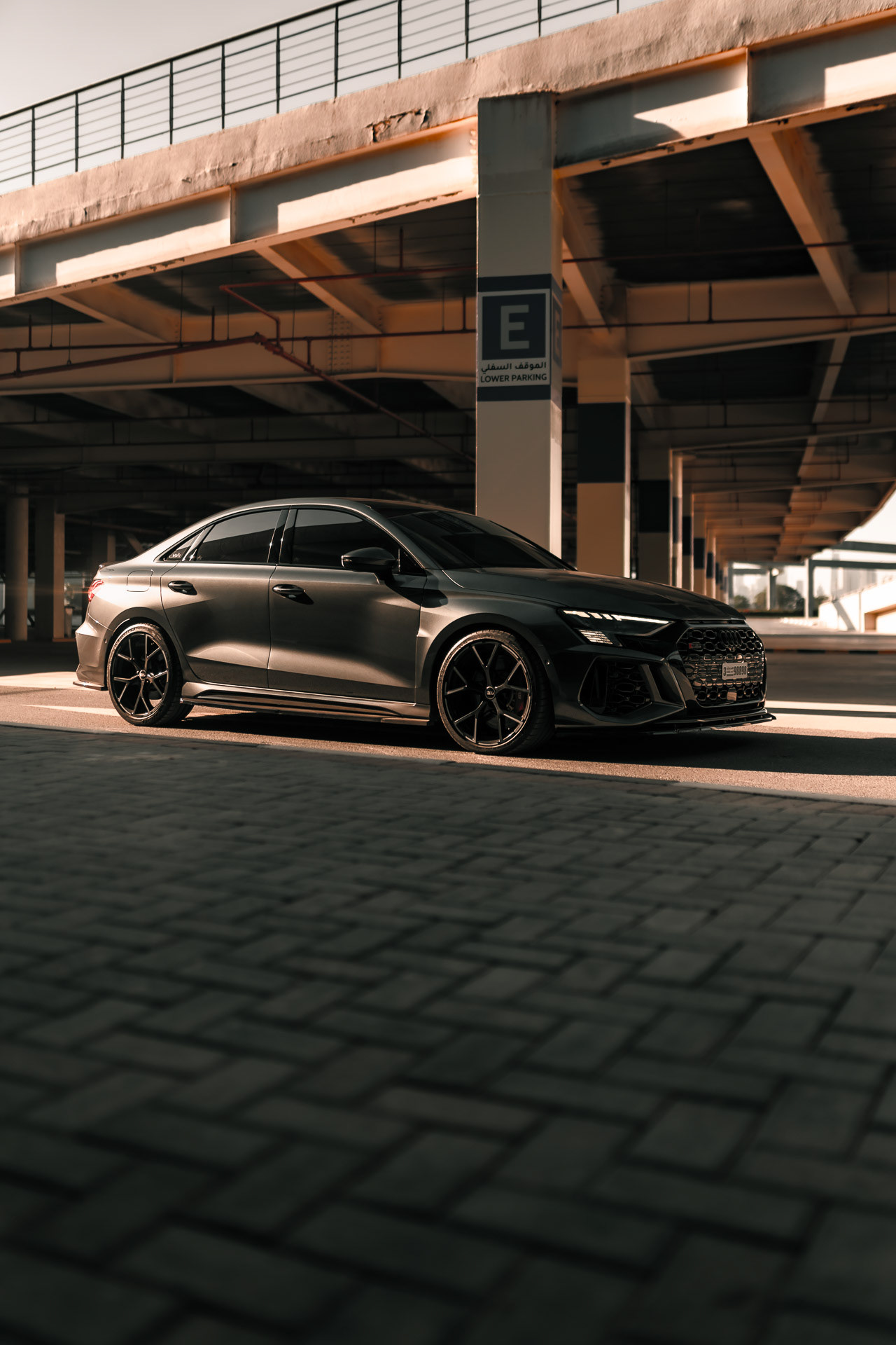 Audi RS3 2023 front view in Dubai parking structure with directional light and shadows