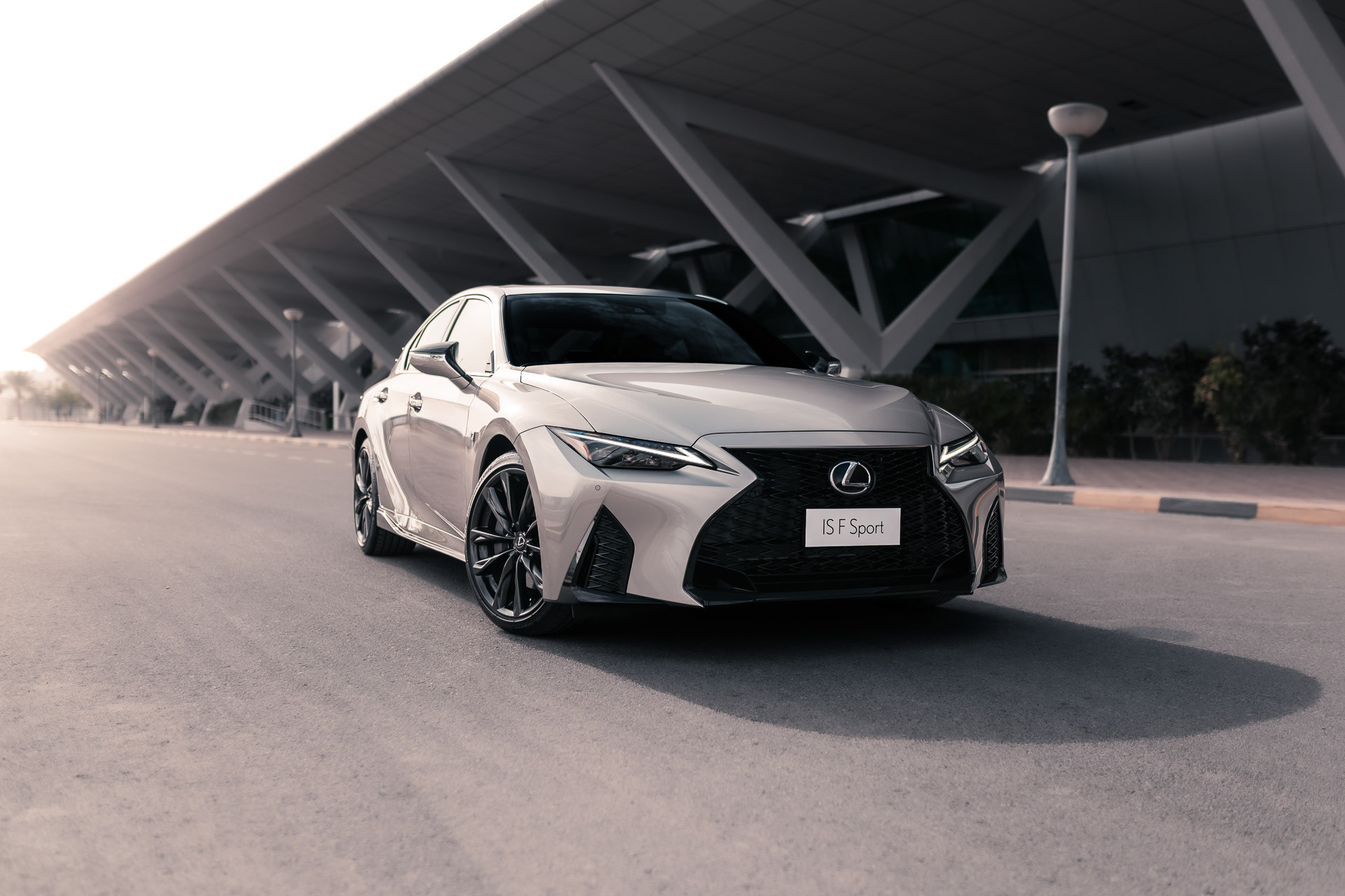 Lexus IS 350 F Sport front 3/4 at Bahrain International Airport, soft morning light