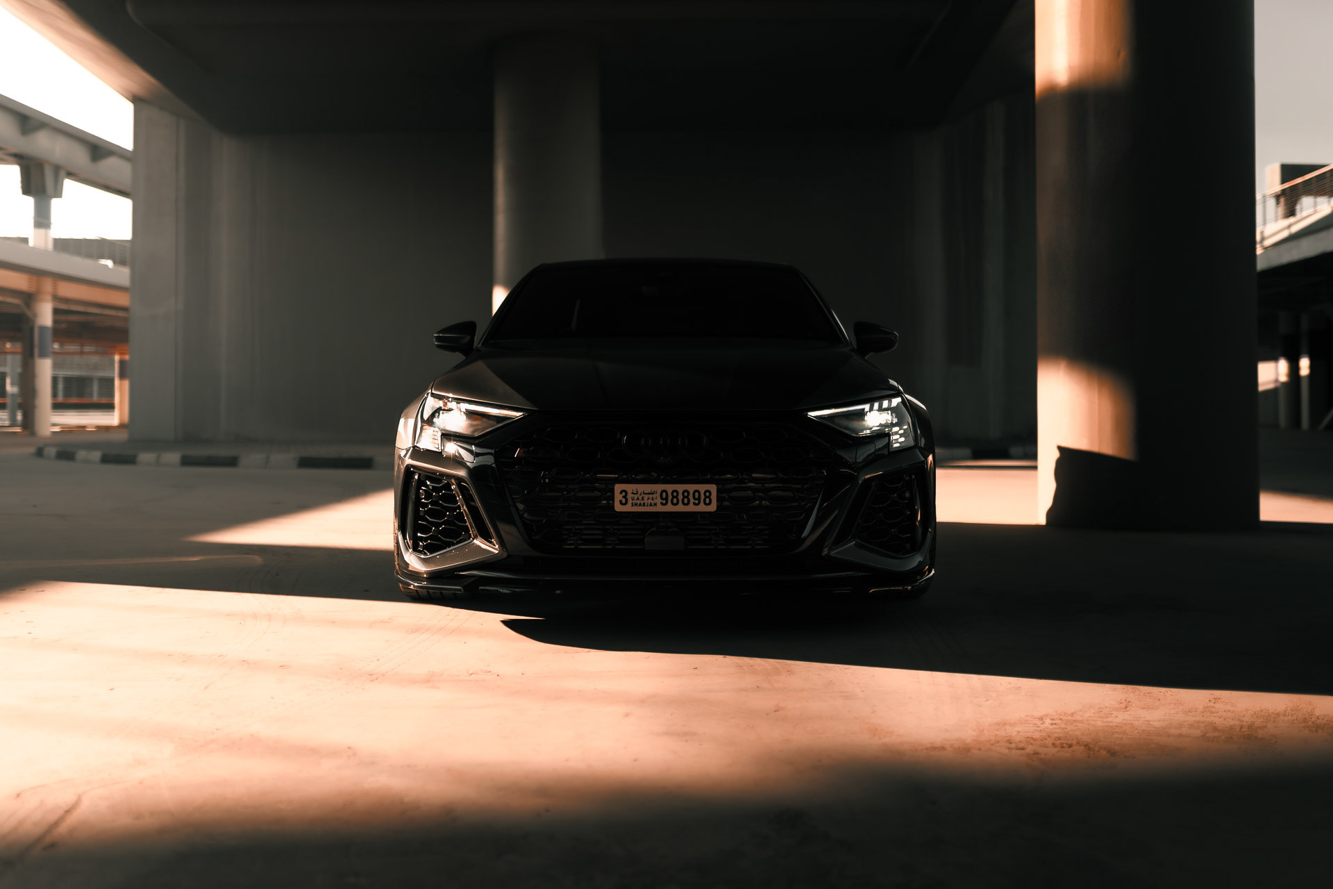Audi RS3 2023 front view in Dubai parking structure with directional light and shadows