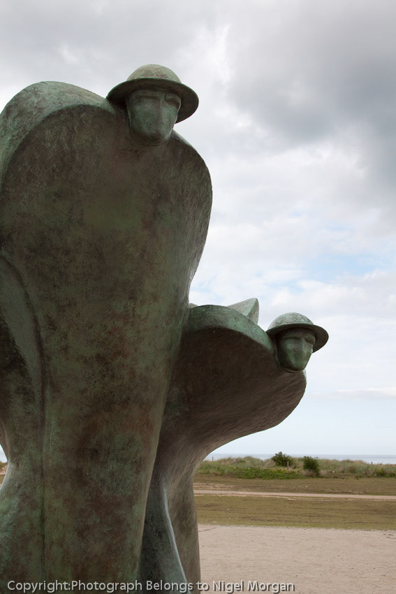 Courseulles-Sur-Mer. Juno Beach - The statue of five soldiers honours those who fought in World War II; especially Canadians at Juno Beach. Featuring 5 soldiers - one for each of 5 D-Day Landing beaches... Juno, Sword, Gold, Utah, and Omaha. The 5 soldiers are joined at the base to represent solidarity. They are standing back-to-back protecting each other.