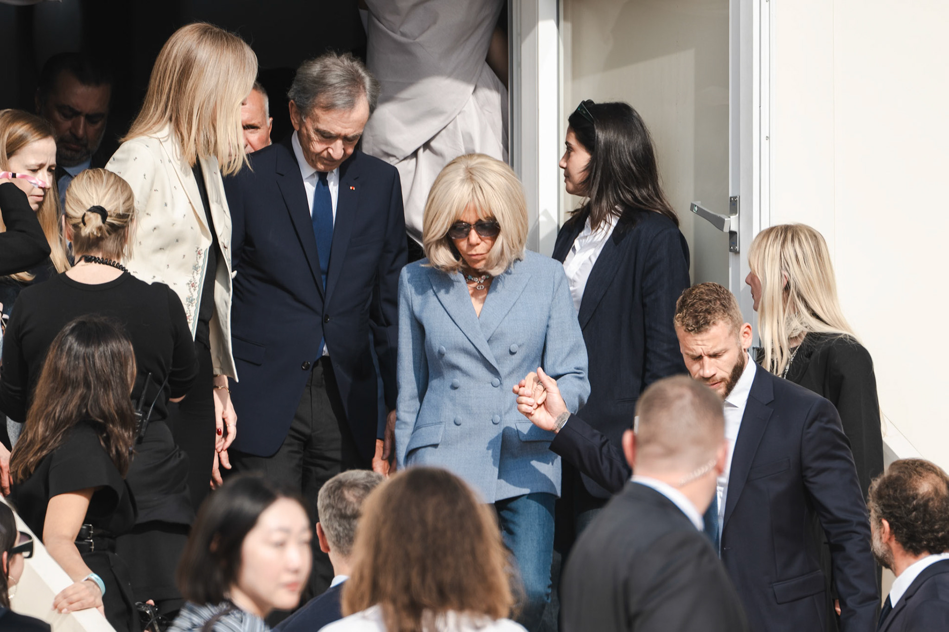 First Lady of France, Brigitte Macron and CEO of Louis Vuitton, Bernard Arnault walk out of Dior fashion show among other guests.