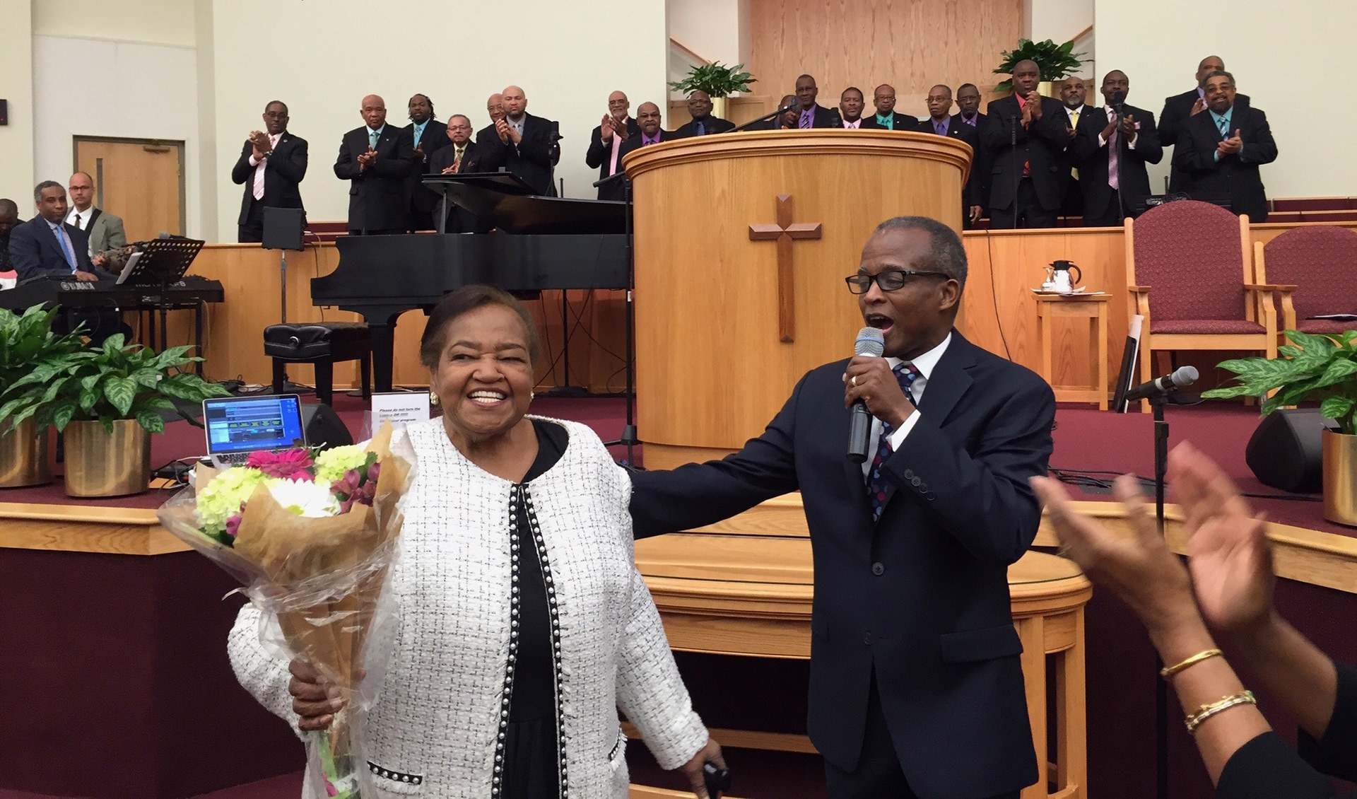 Rev. Woolford, the last living founder of St. John Baptist Church, is presented with flowers for the church's 45th anniversary.