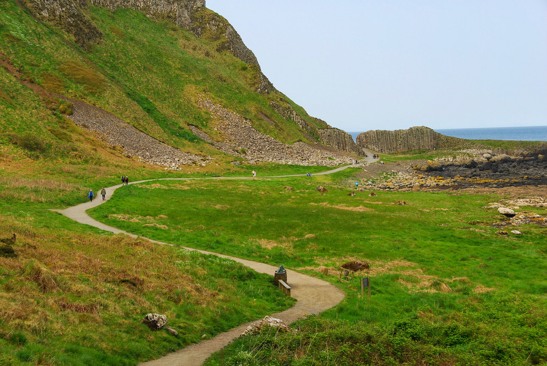 Tourists walking among hexagonal stones at Giant's Causeway