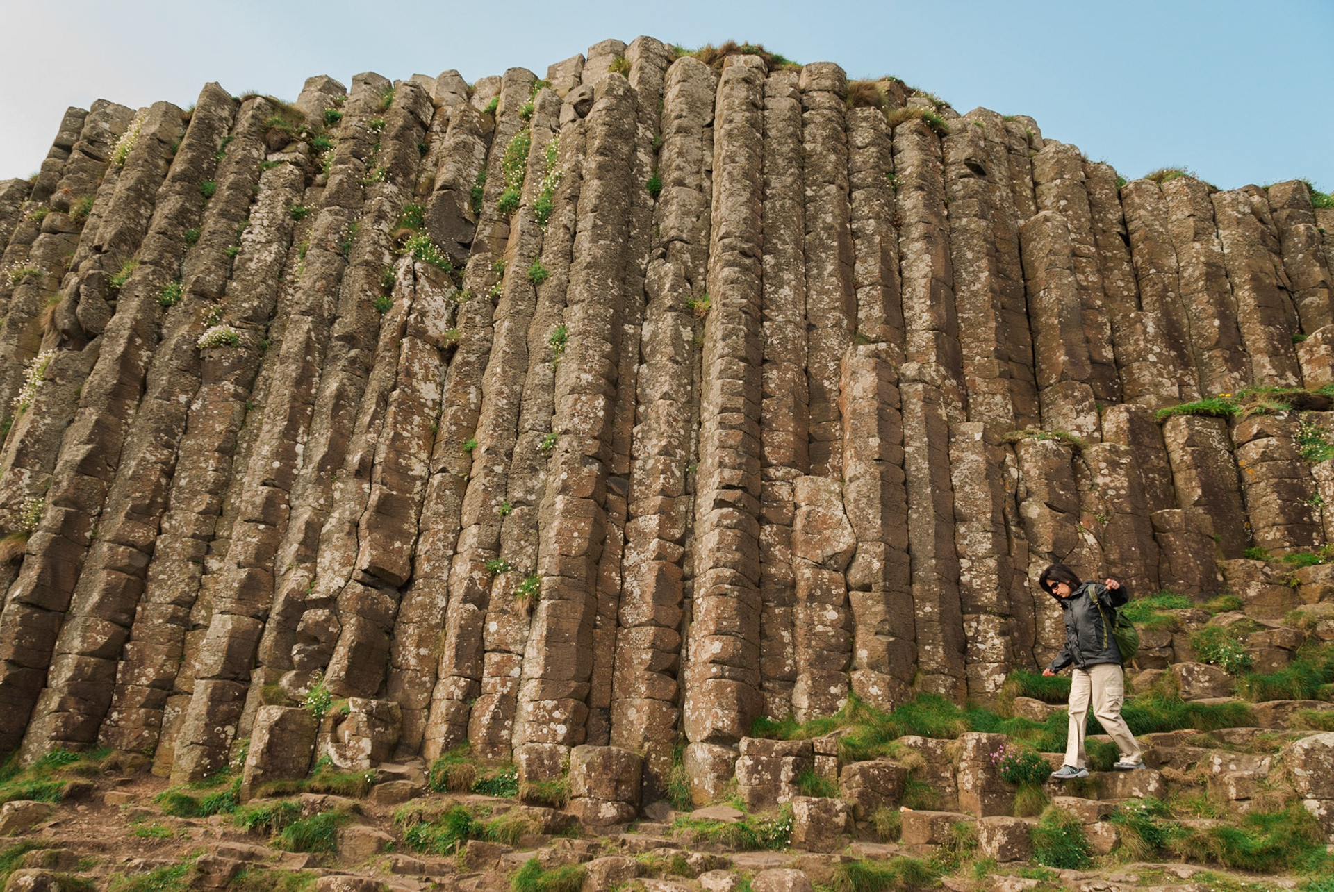 Woman walking among hexagonal stones at Giant's Causeway