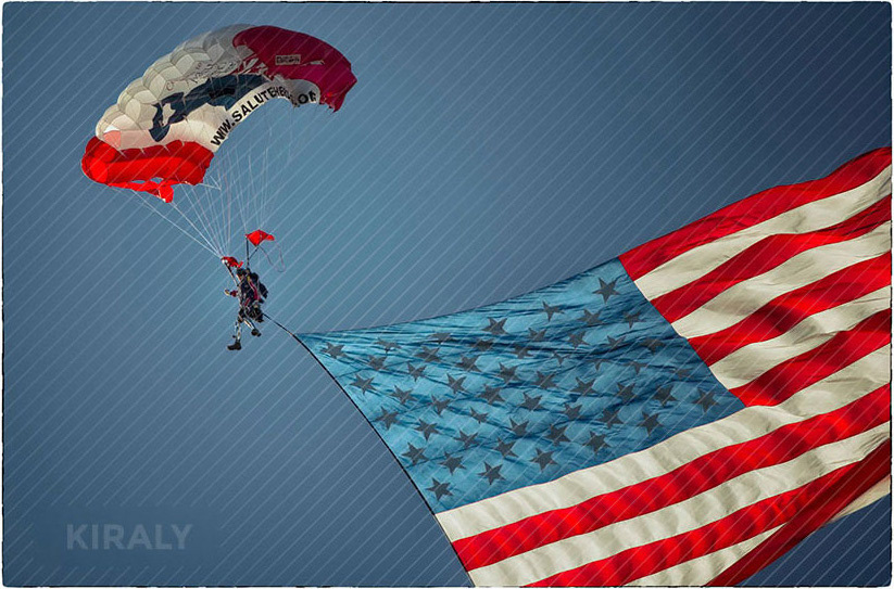 Photo of military vets parachuting with an enormous American flag trailing them