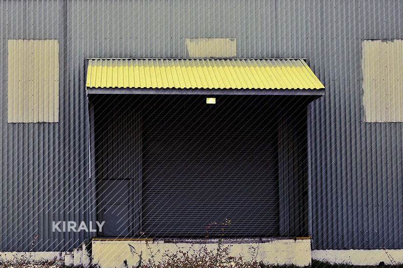 Photo of a warehouse loading dock that abstractly looks like a one-toothed face crying out
