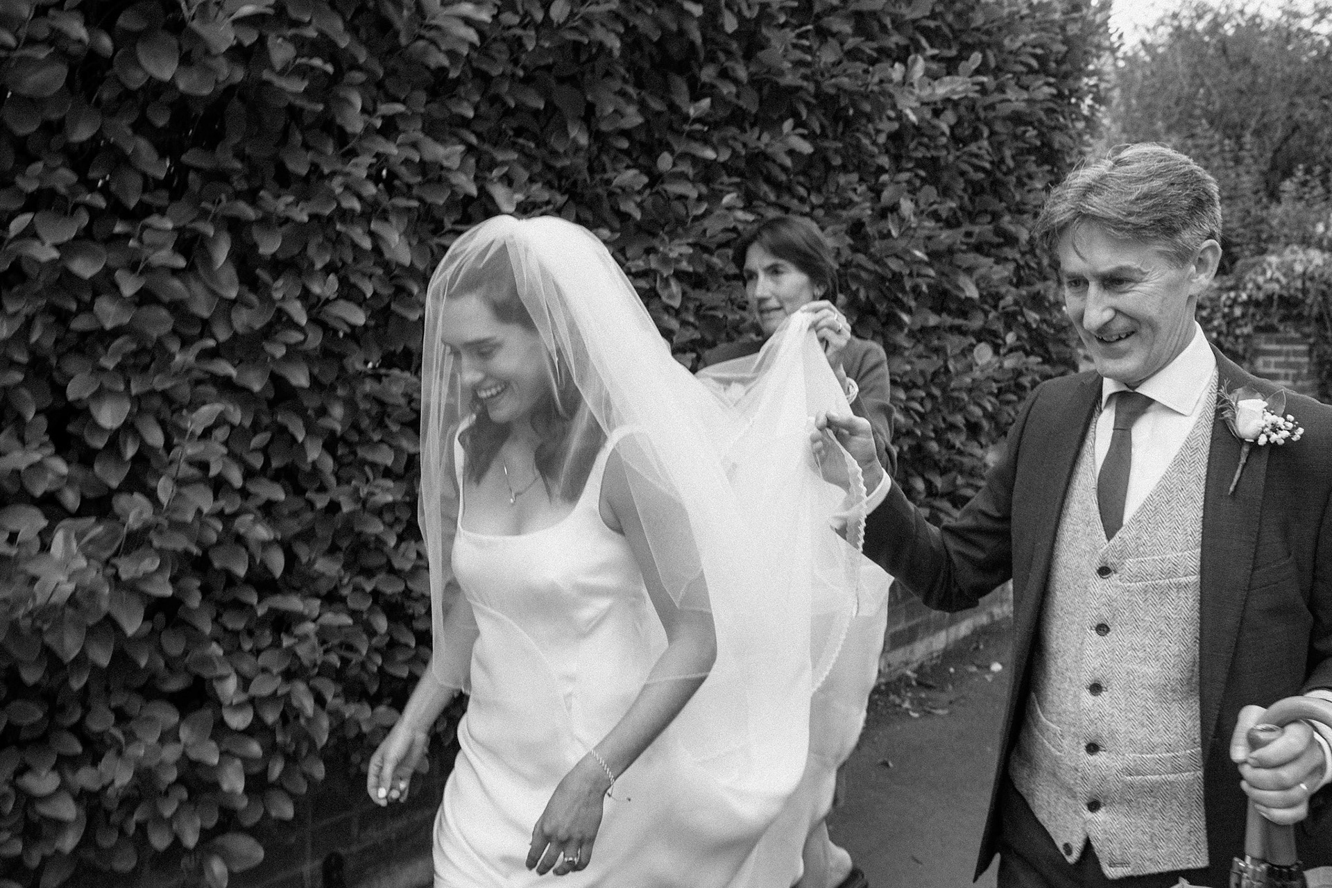 The bride walking to the church, accompanied by her parents. 