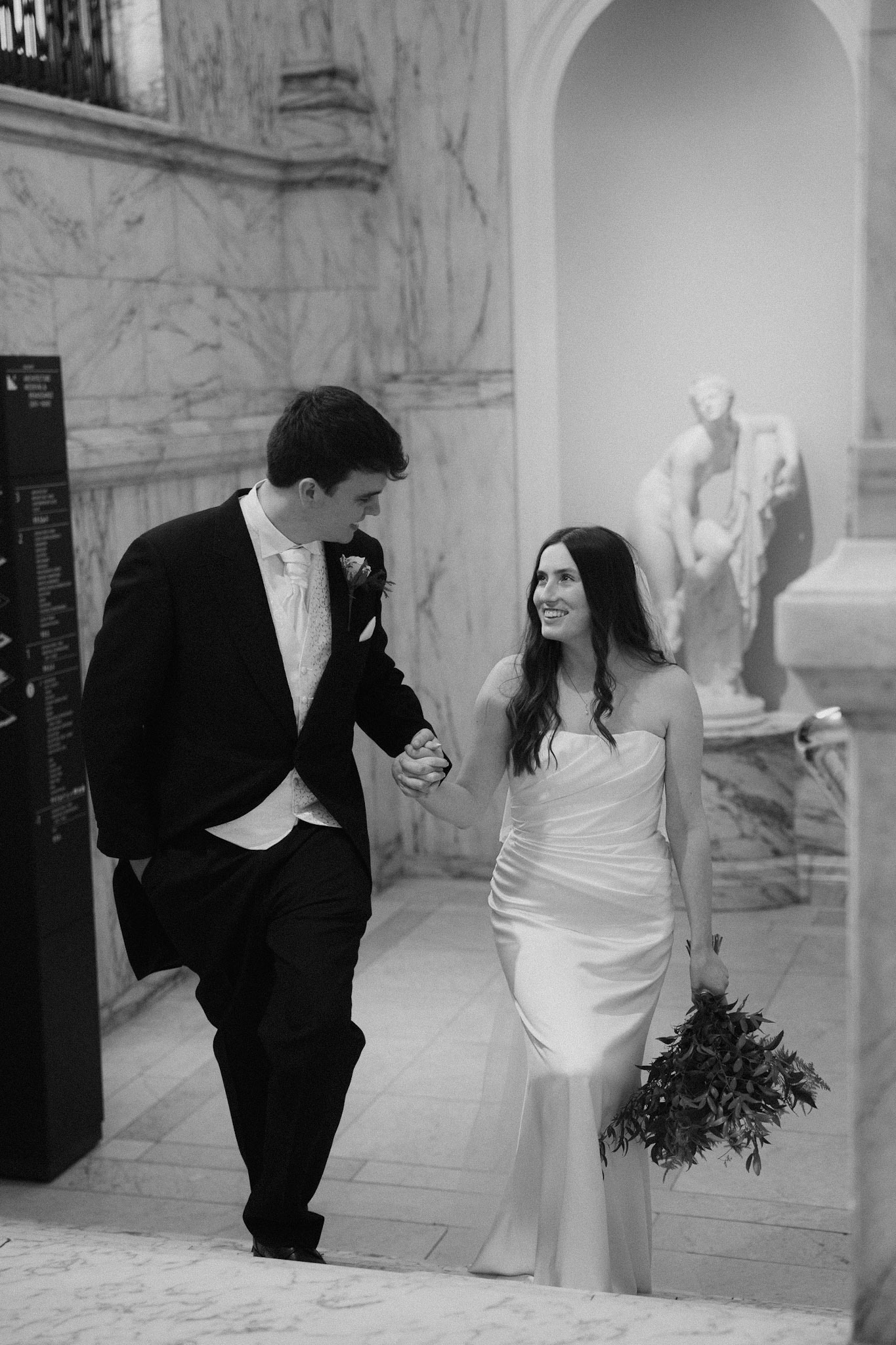 Bride and groom share a moment while walking the hallways of the Victoria and Albert museum. 