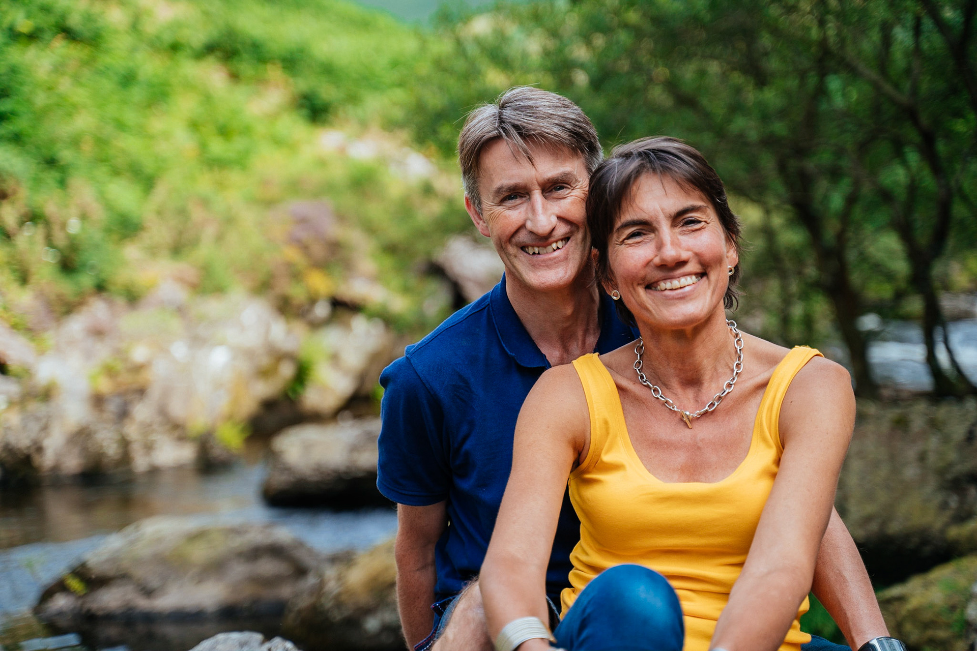 Portrait of a couple smiling, taken outdoors during a portrait session.