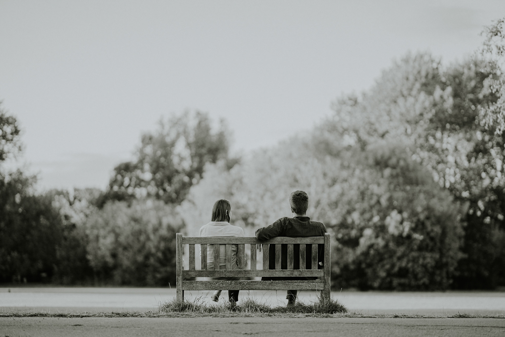 A couple share a moment of peace in the park. Taken during and engagement photoshoot in Wimbledon