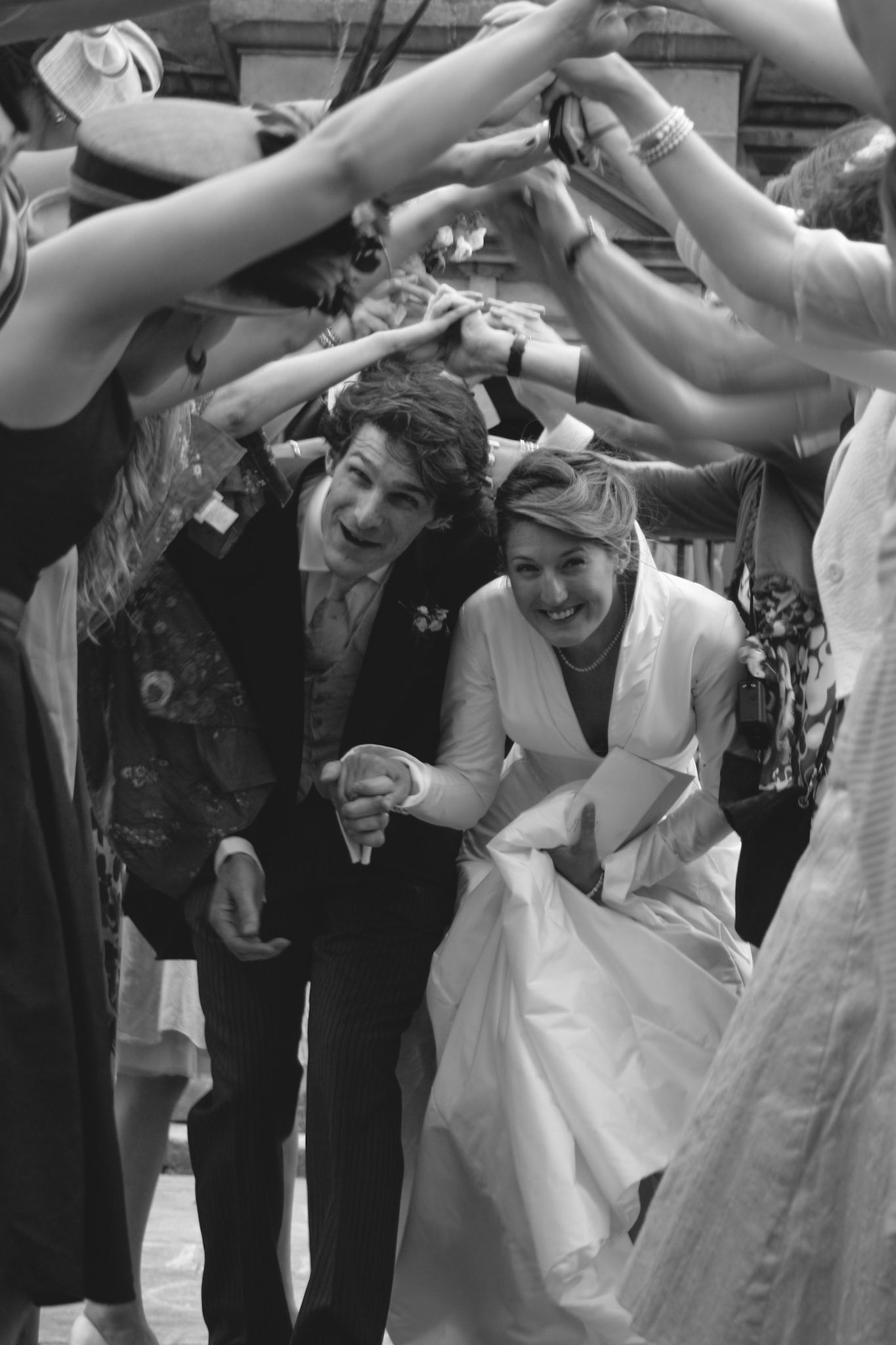 The bride and groom going through the tunnel of happy friends