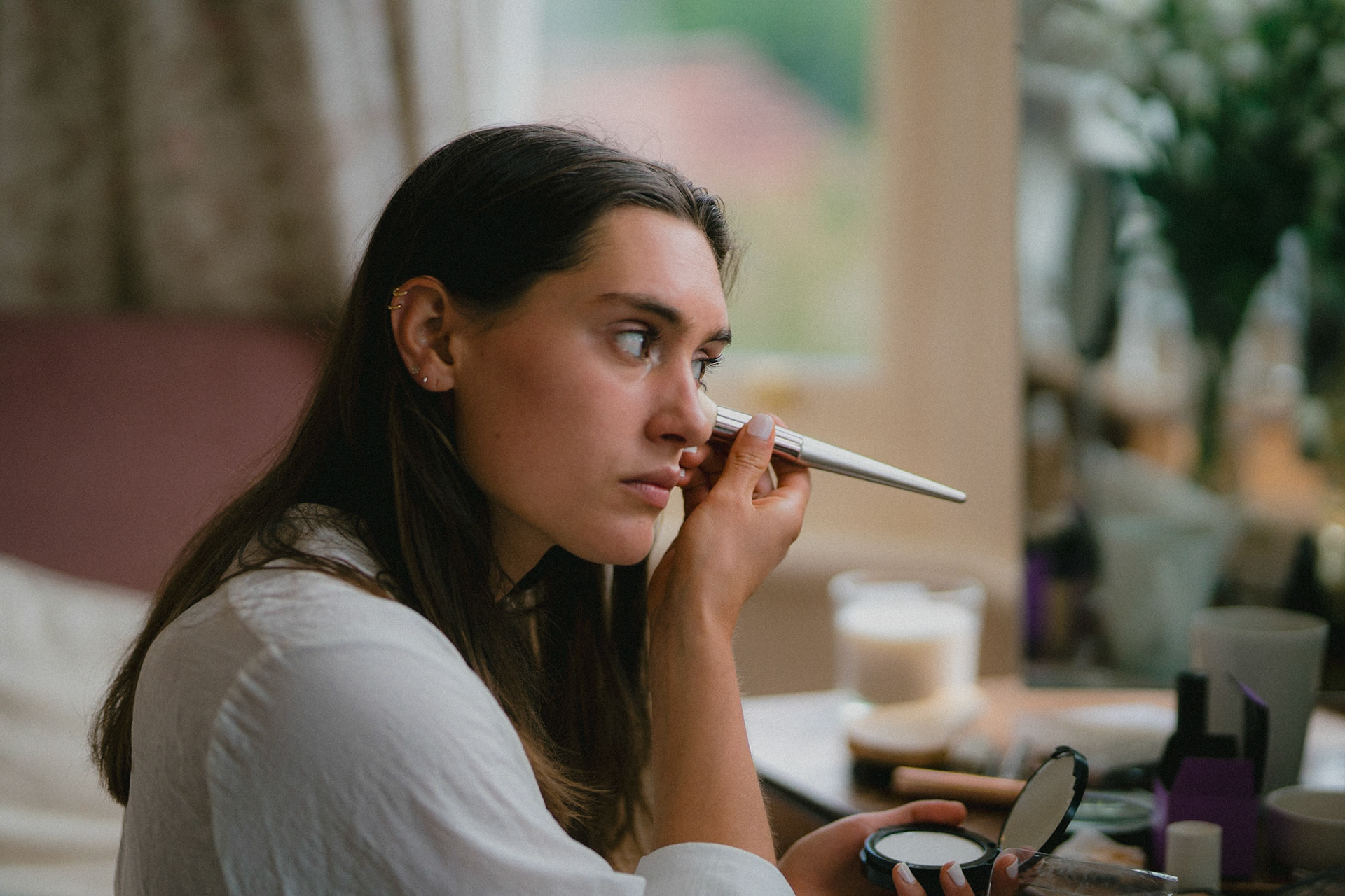 The bride applying makeup on the morning of her wedding