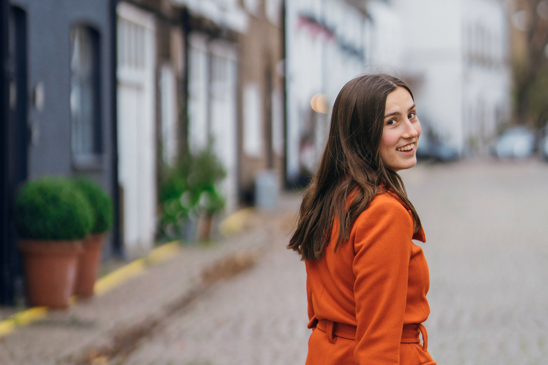 Candid portrait of a young woman smiling, taken outdoors with natural light