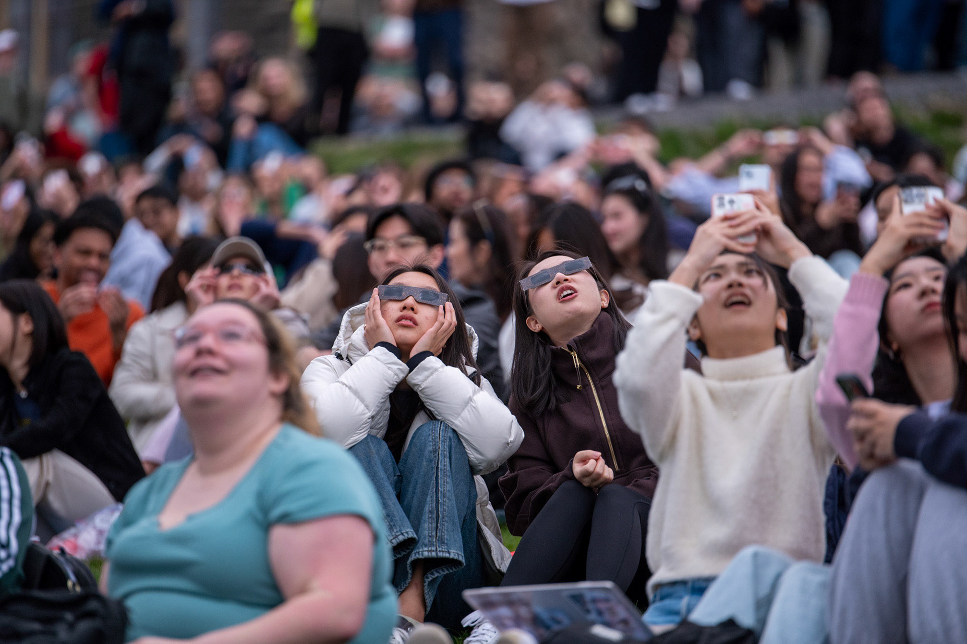 Students caught glimpses of the solar eclipse on Libe Slope, April 8th, 2024. (Ming DeMers/Sun Senior Photo)