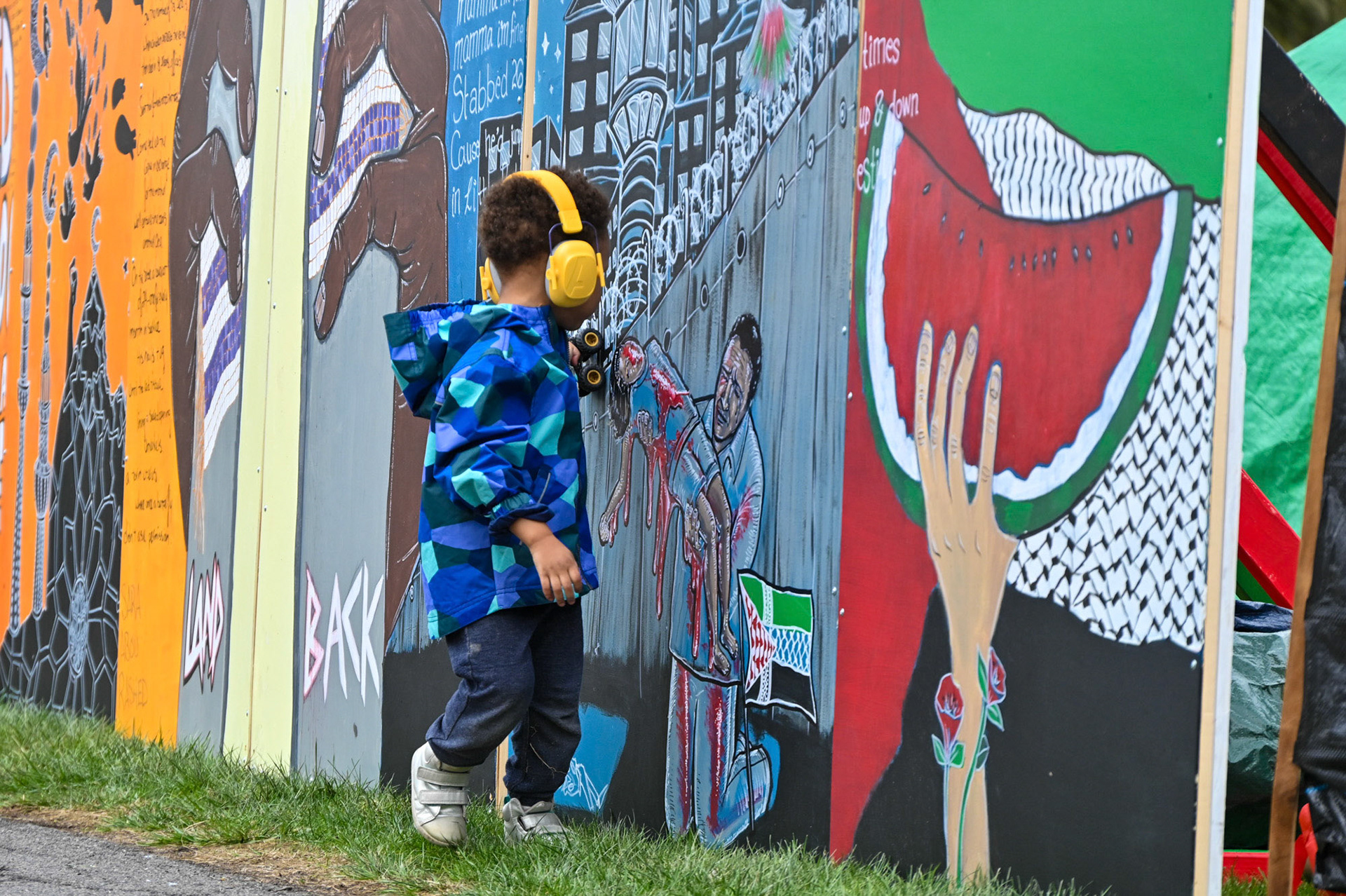 A child looks at the mural at the CML Liberated Zone Encampment on the Arts Quad, April 28th, 2024. (Ming DeMers/Sun Senior Photo)