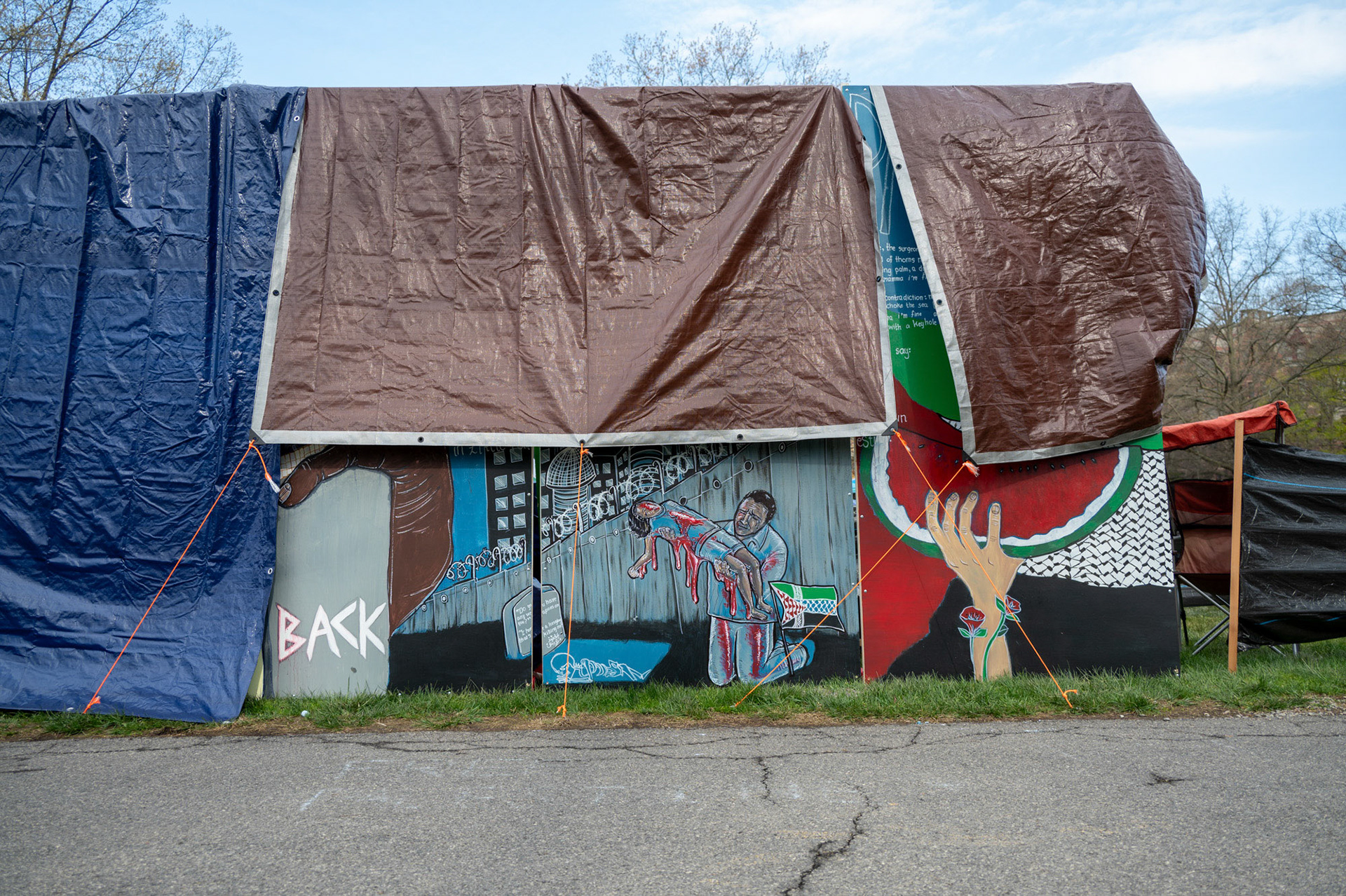 Tarps protect the mural from rain on the fourth day of the CML Liberated Zone Encampment on the Arts Quad, April 28th, 2024. (Ming DeMers/Sun Senior Photo)