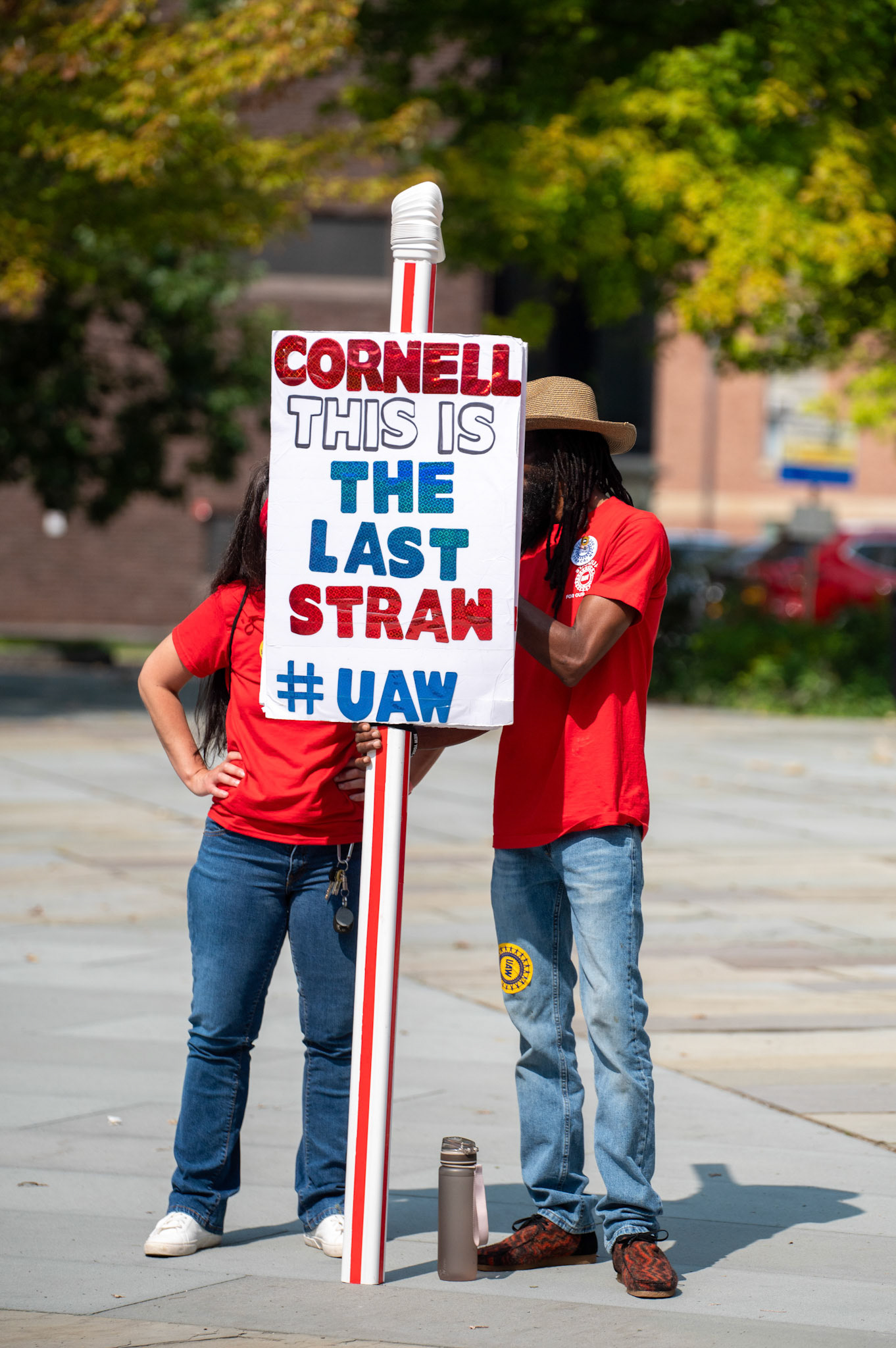 A sign at the UAW 2300 Rally and March outside of Bailey Hall, August 16th, 2024. (Ming DeMers/Sun Photo Editor)