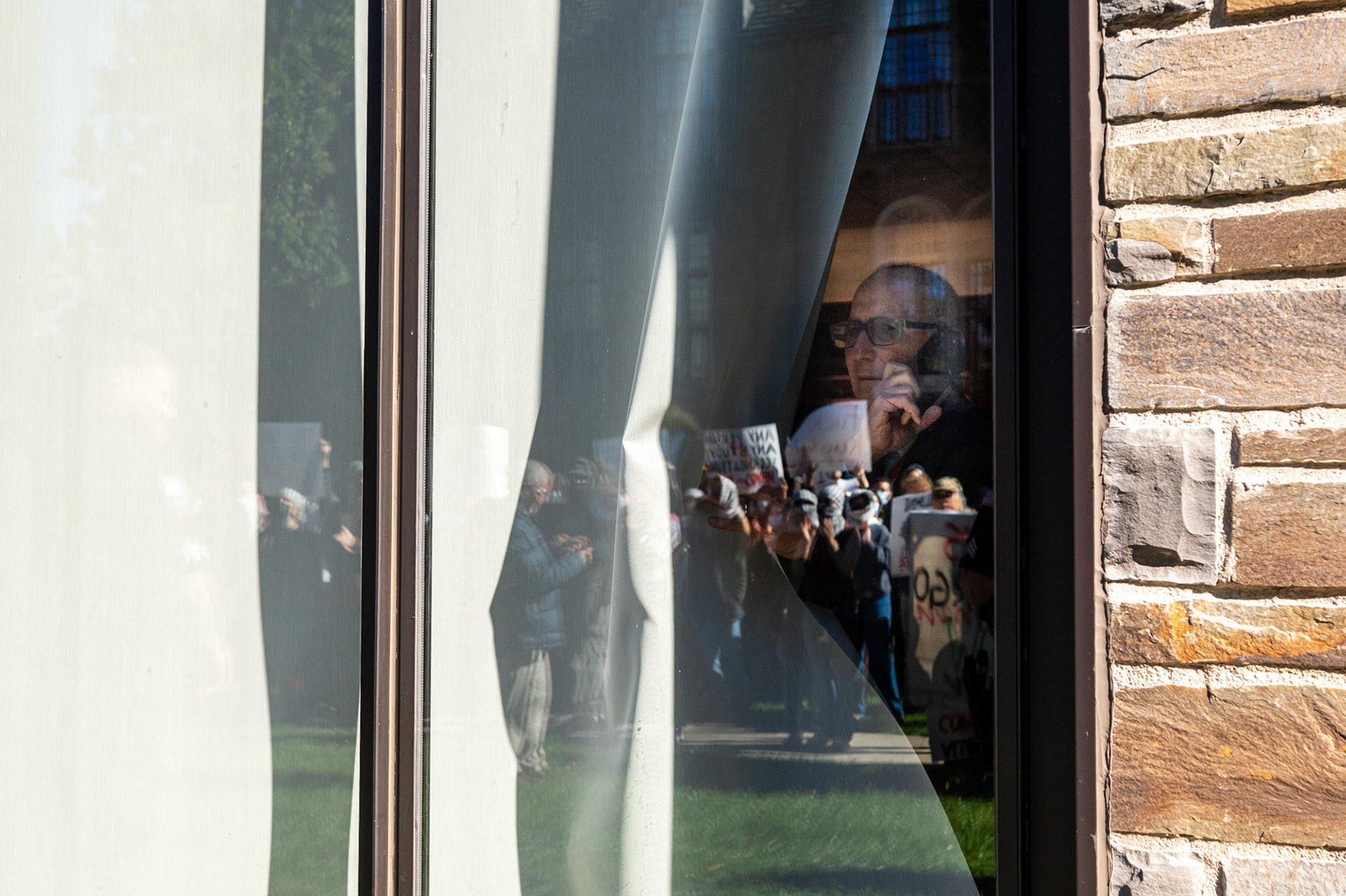 A board of trustees member looks out from the conference at the CML Rally Walkout of the Board of Trustees Meeting at the Law School, Myron Taylor Hall Courtyard, Oct 18, 2024. (Ming DeMers/Sun Photography Editor)