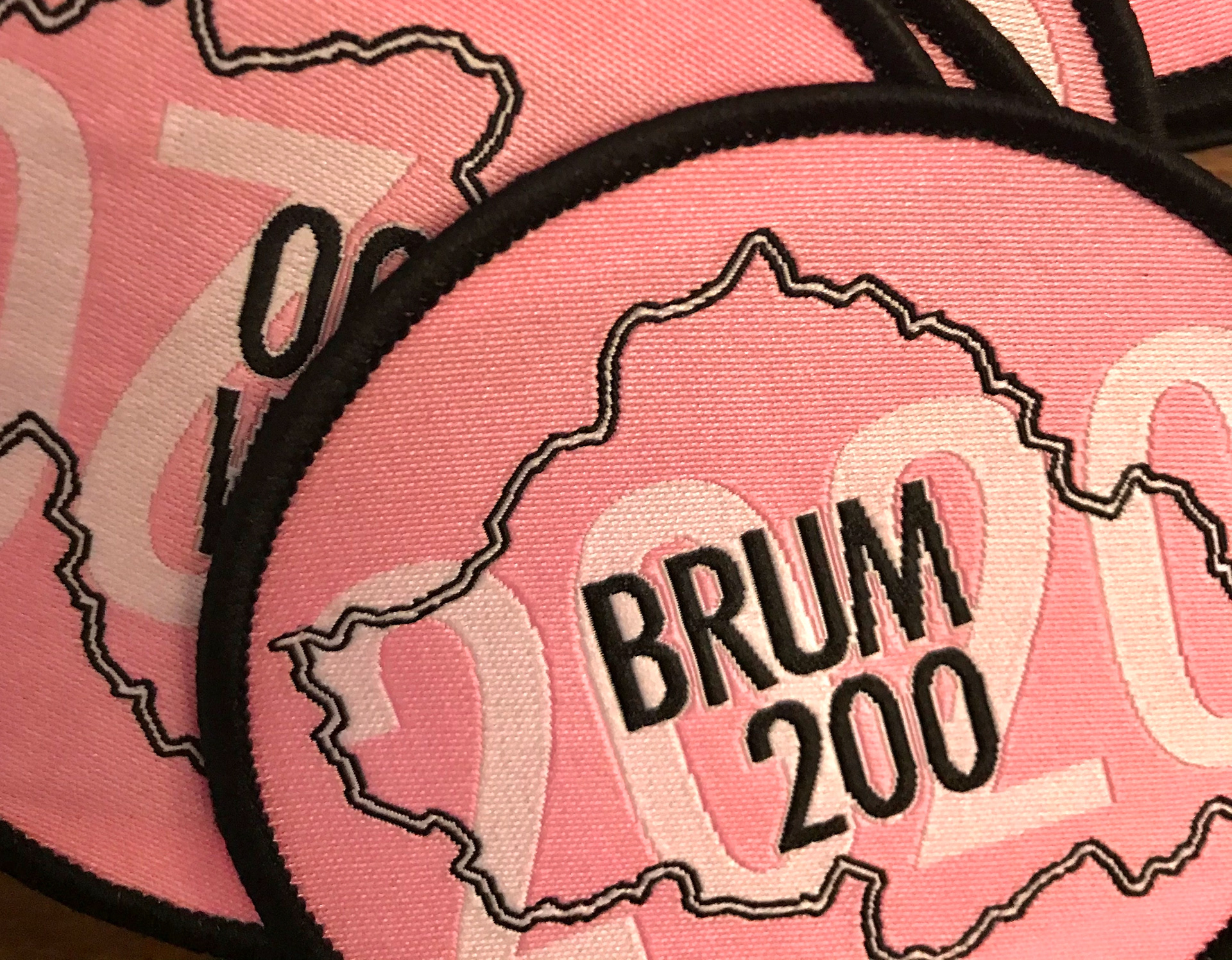 Commemorative embroidered patches for the BRUM 200, 2020, featuring the pink version of the logo for one of the event years.