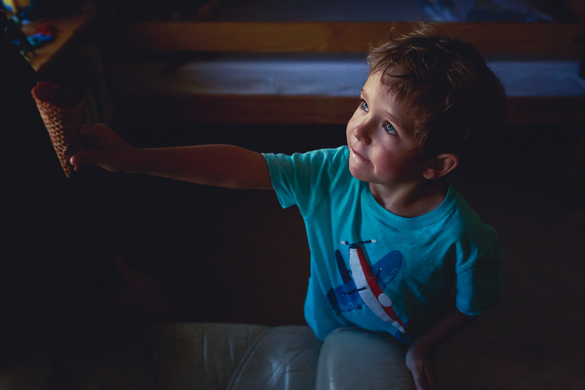 Boy handing empty ice cream cone to someone