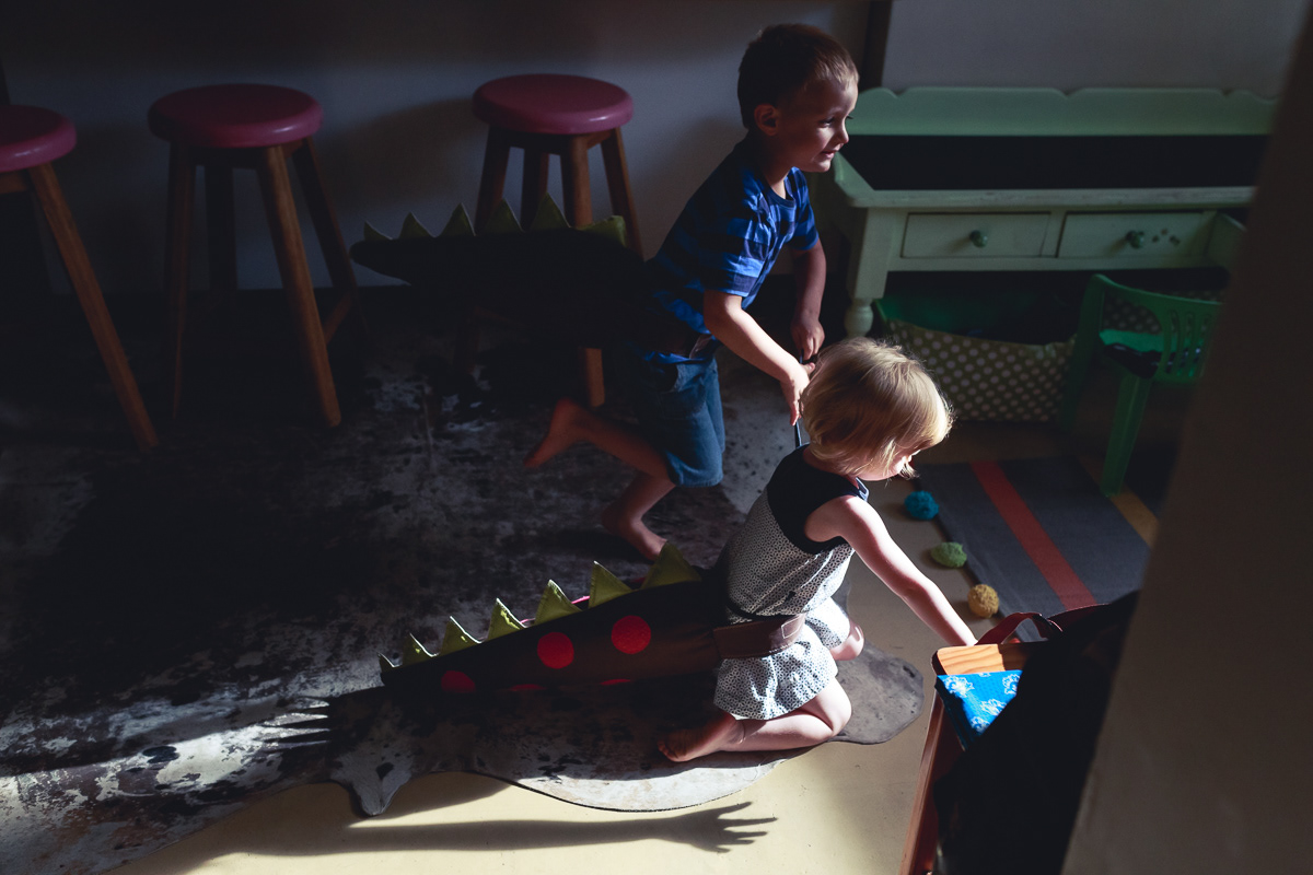 Boy and girl pretend play they are dinosaurs
