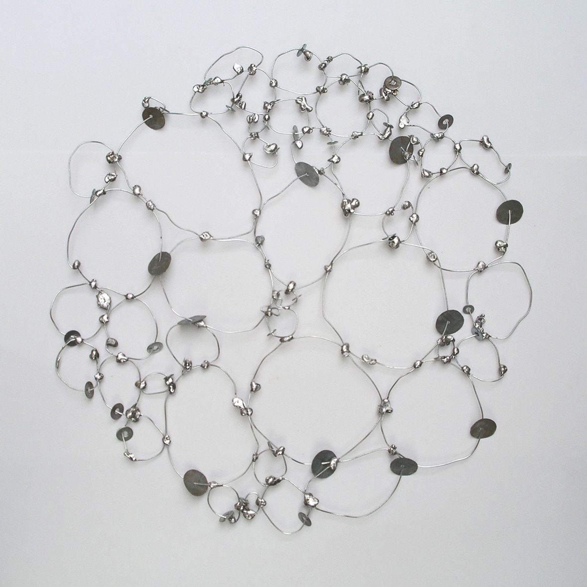 Células (Cells), wall sculpture, wire and tin solder, diameter 17.3 in, 2004.